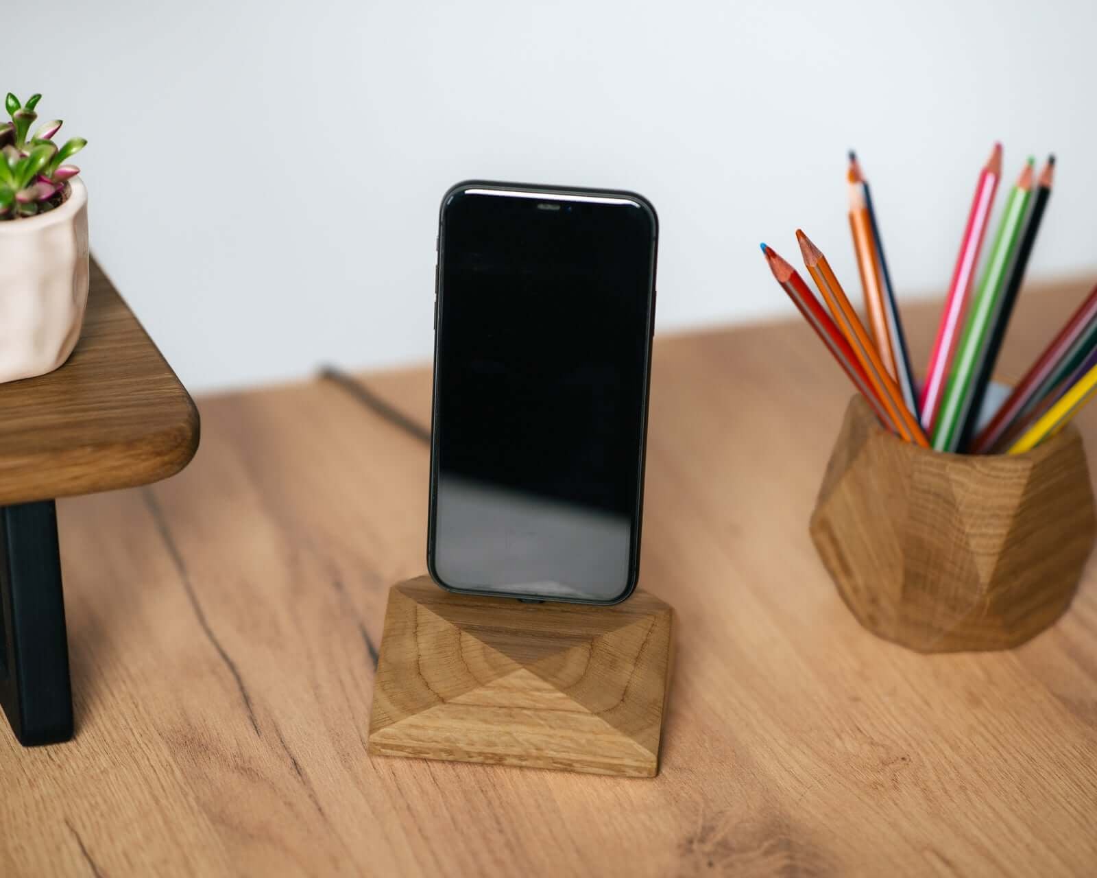Charging Station with a wooden phone stand, showcasing desk organization with a smartphone and colorful pencils.