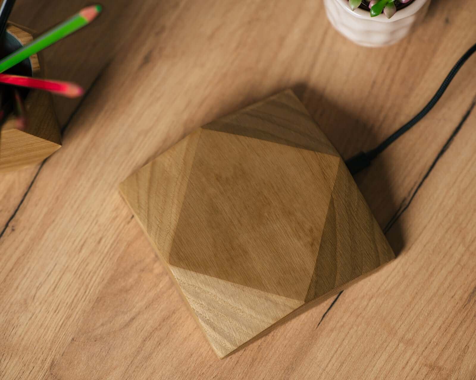 Wireless Charger with a geometric wooden design on a wooden desk, ideal for modern home decor.