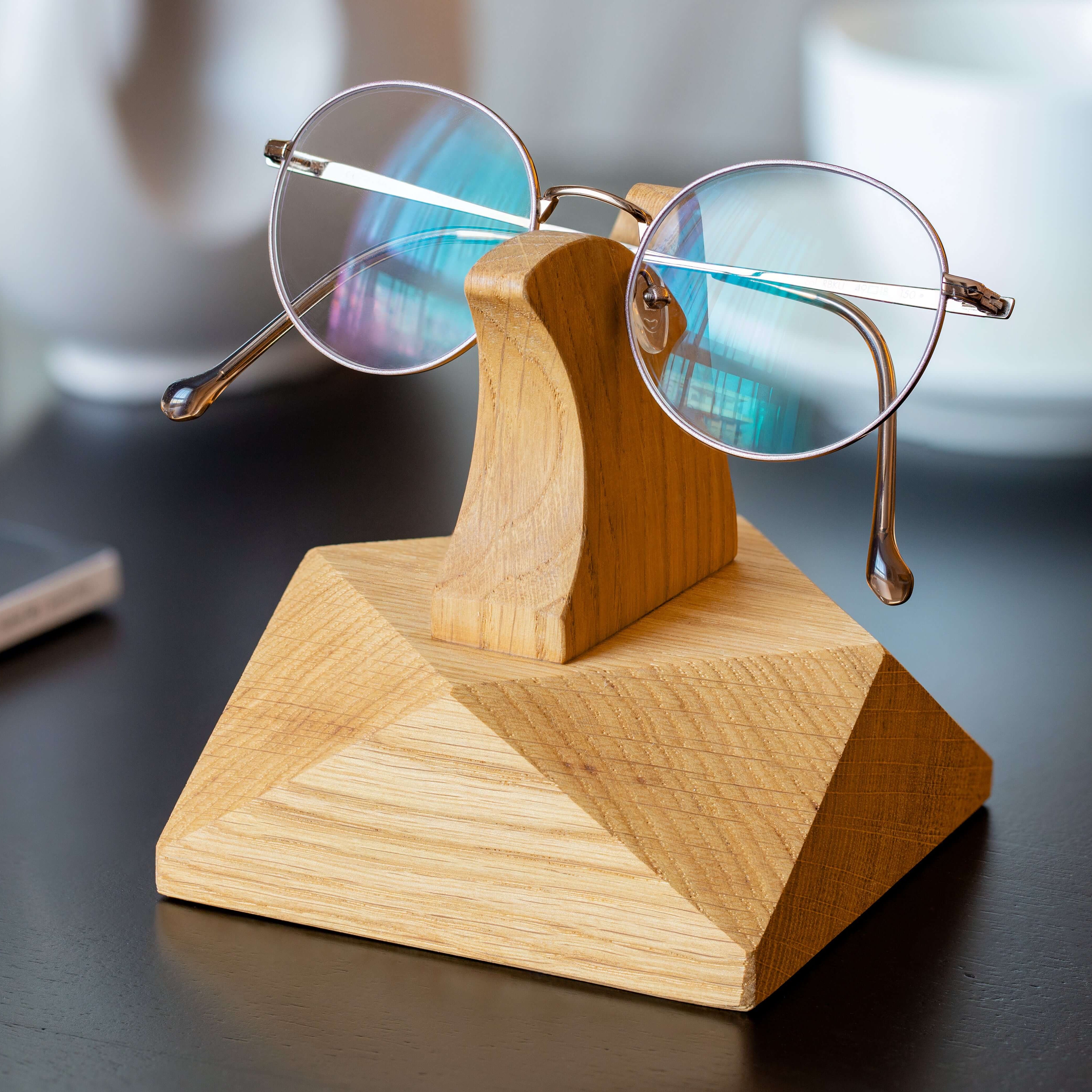 Handcrafted wooden eyeglasses stand displaying stylish glasses on a desk, perfect for organization and home decor.