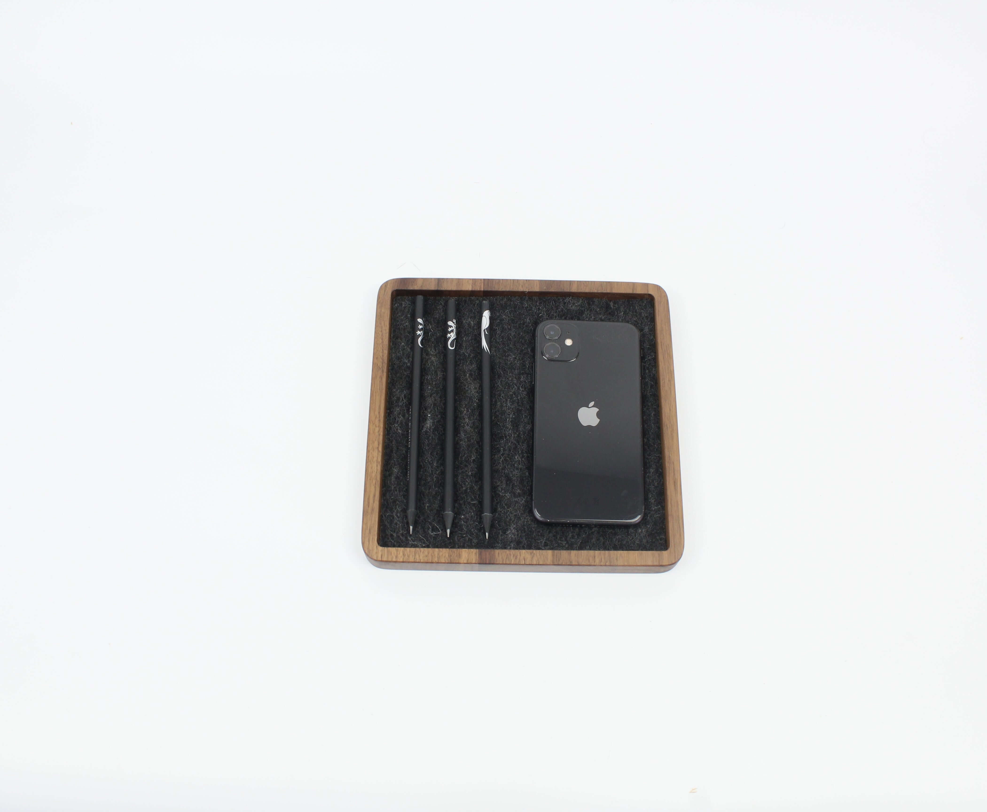 Square walnut Catch All Tray with pens and smartphone, ideal for desk organization and stylish storage.