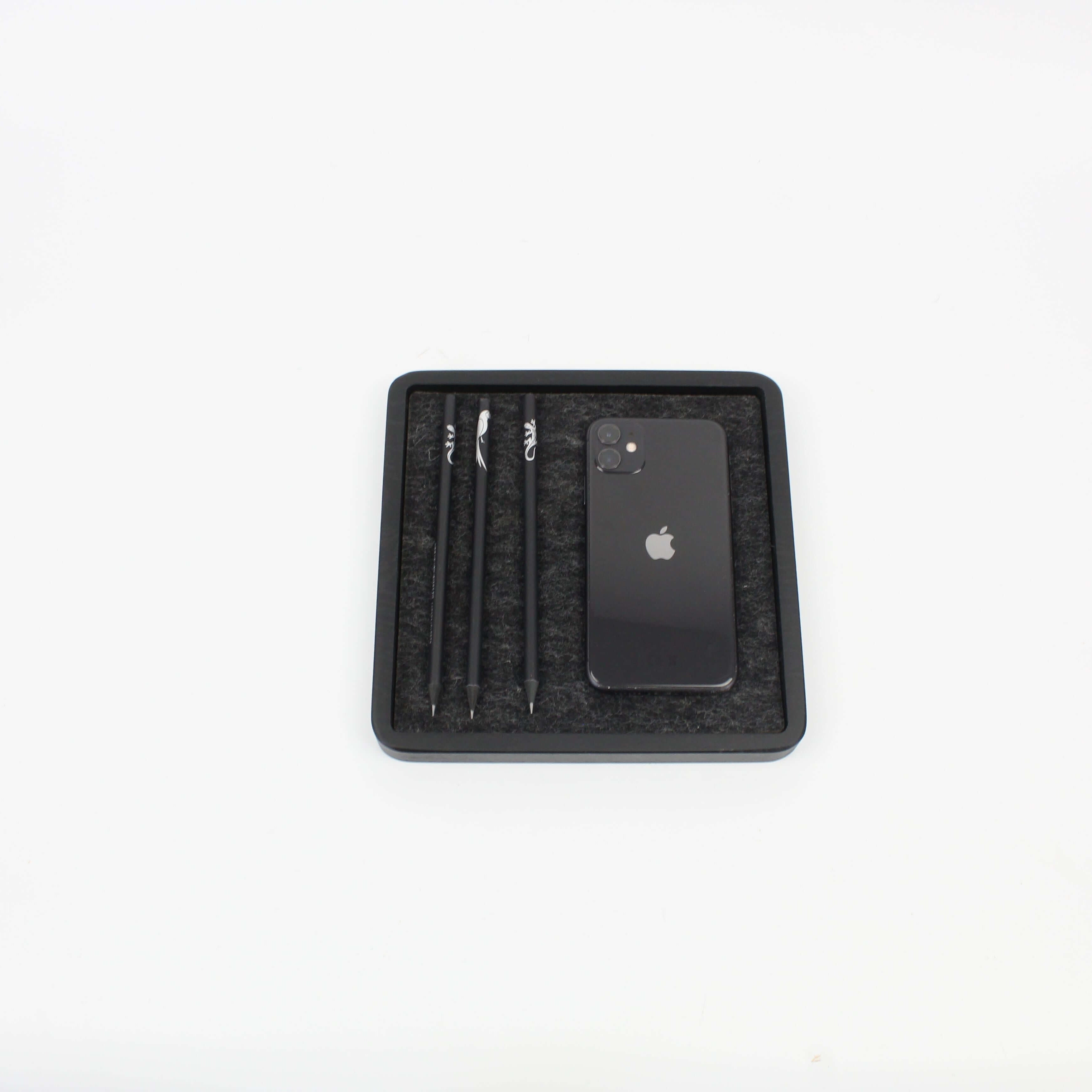 Black oak catch all tray with phone and pens organized, ideal desk accessory for a tidy workspace.