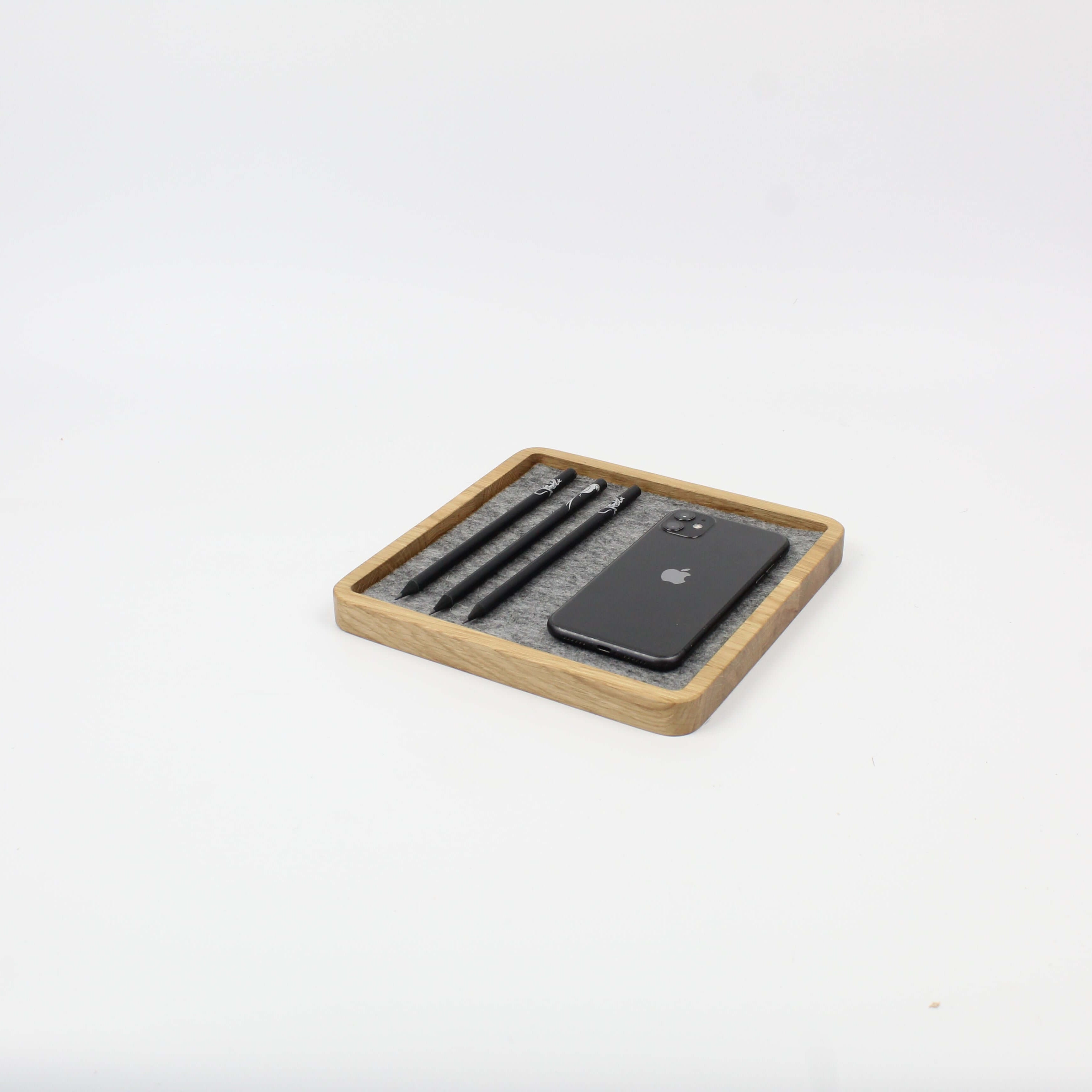Catch All Tray in oak wood organizing a smartphone and pens, ideal desk accessory for a tidy workspace.