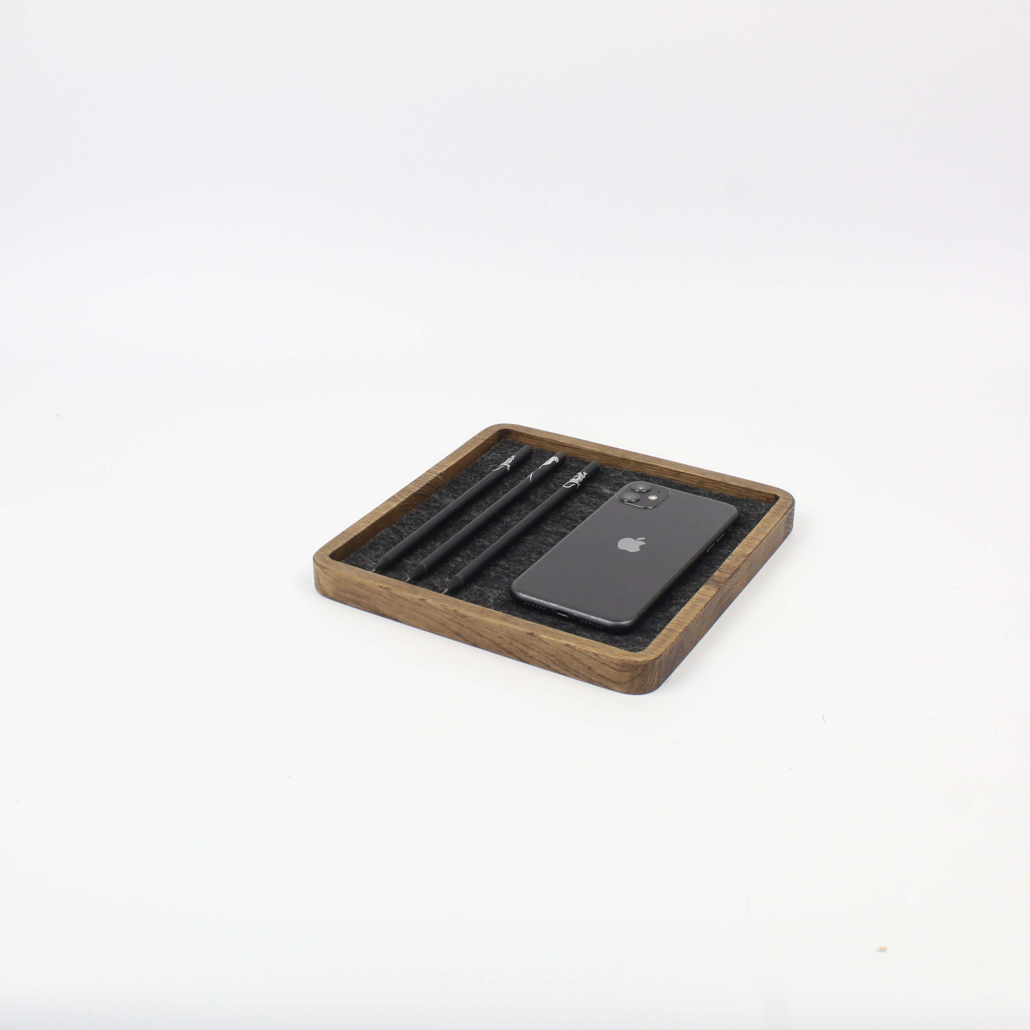 Brown oak catch all tray with smartphone and pens, perfect for desk organization and accessories.