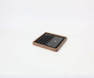 Walnut square catch all tray organizing a phone and pens, ideal desk accessories for a tidy workspace.