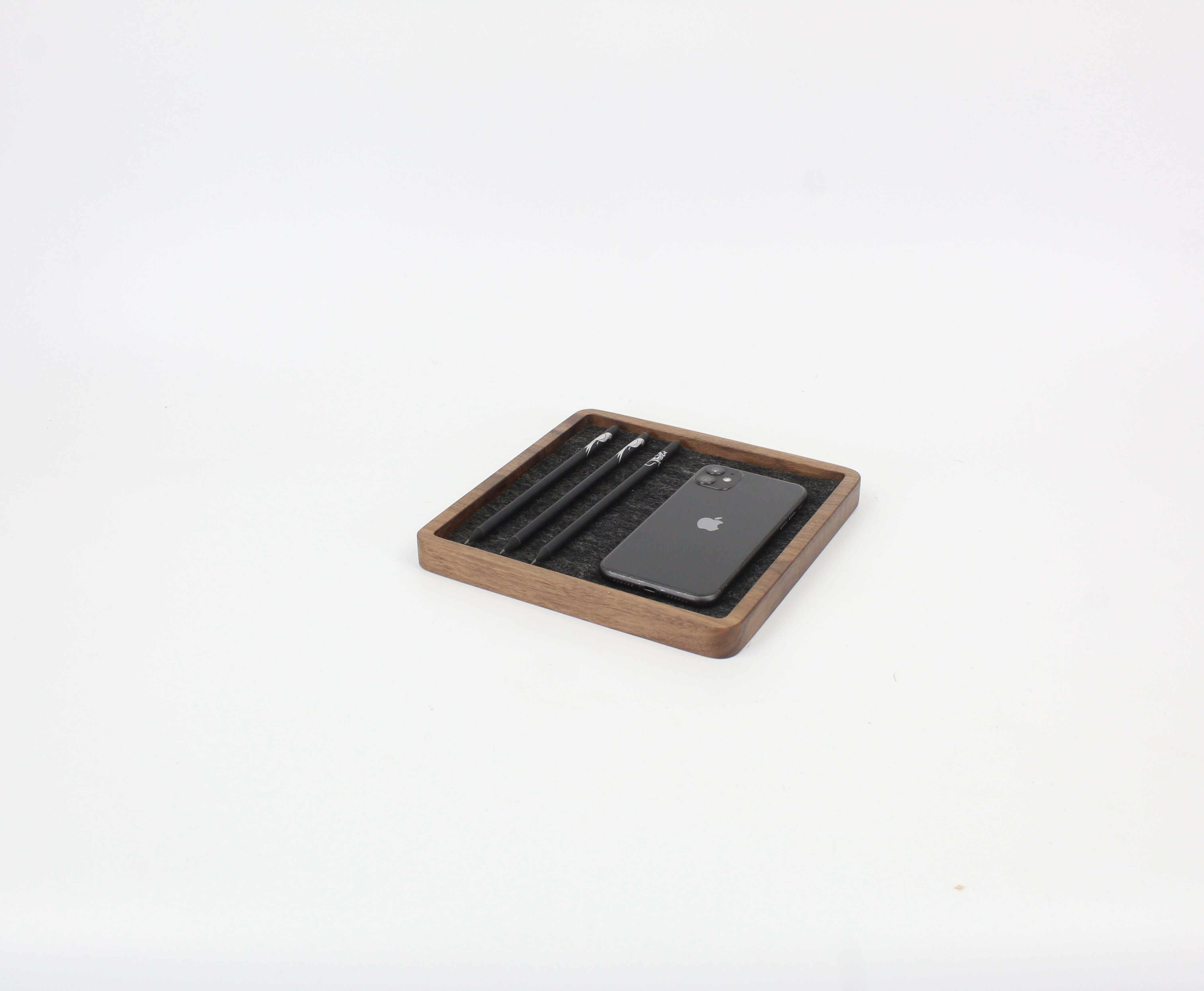 Walnut square catch all tray organizing a phone and pens, ideal desk accessories for a tidy workspace.