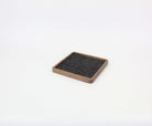 Square walnut catch all tray with felt lining, ideal for organizing desk essentials and enhancing workspace aesthetics.