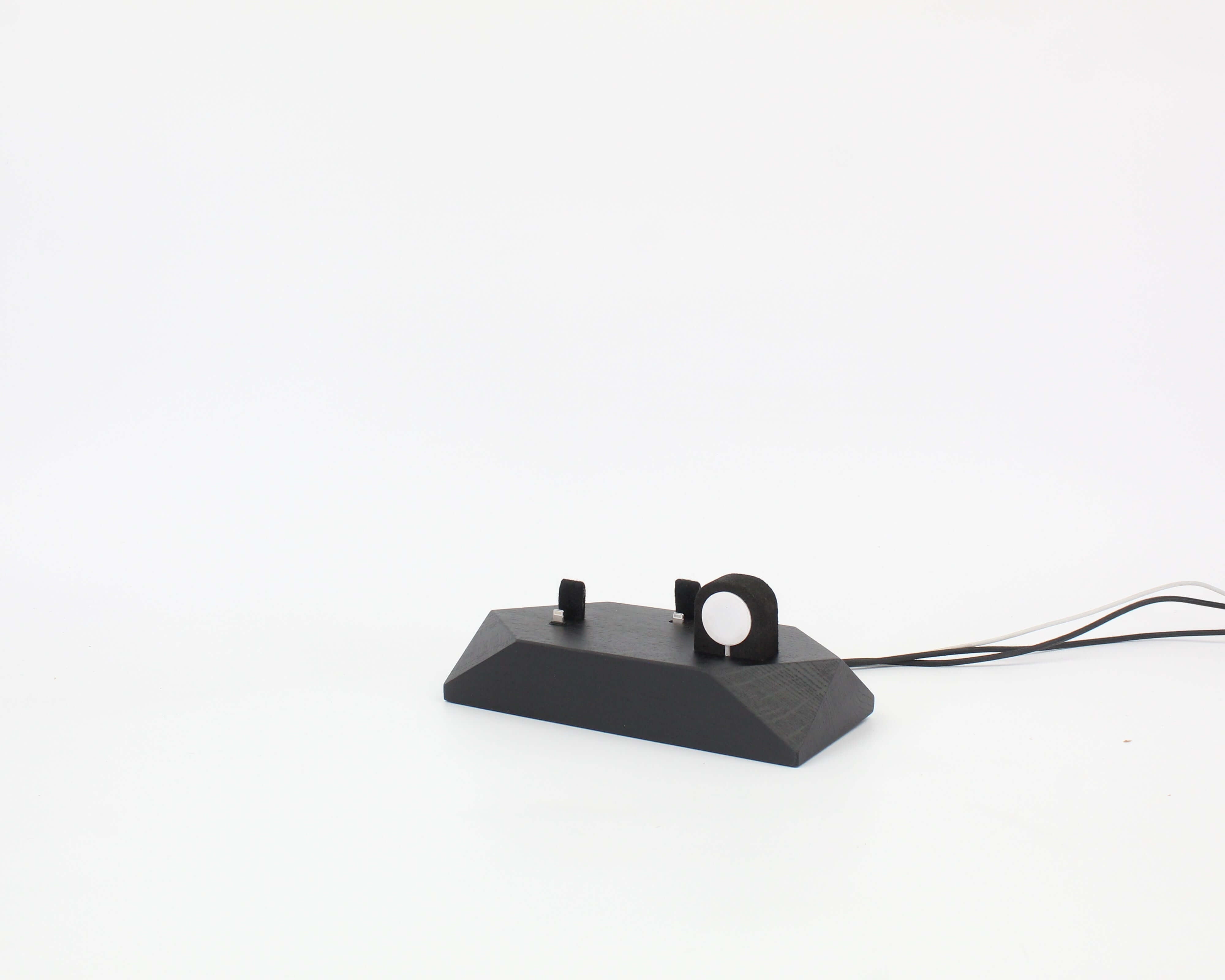 Triple Phone Dock in Black Oak, designed to hold two smartphones and an Apple Watch, enhancing workspace organization.
