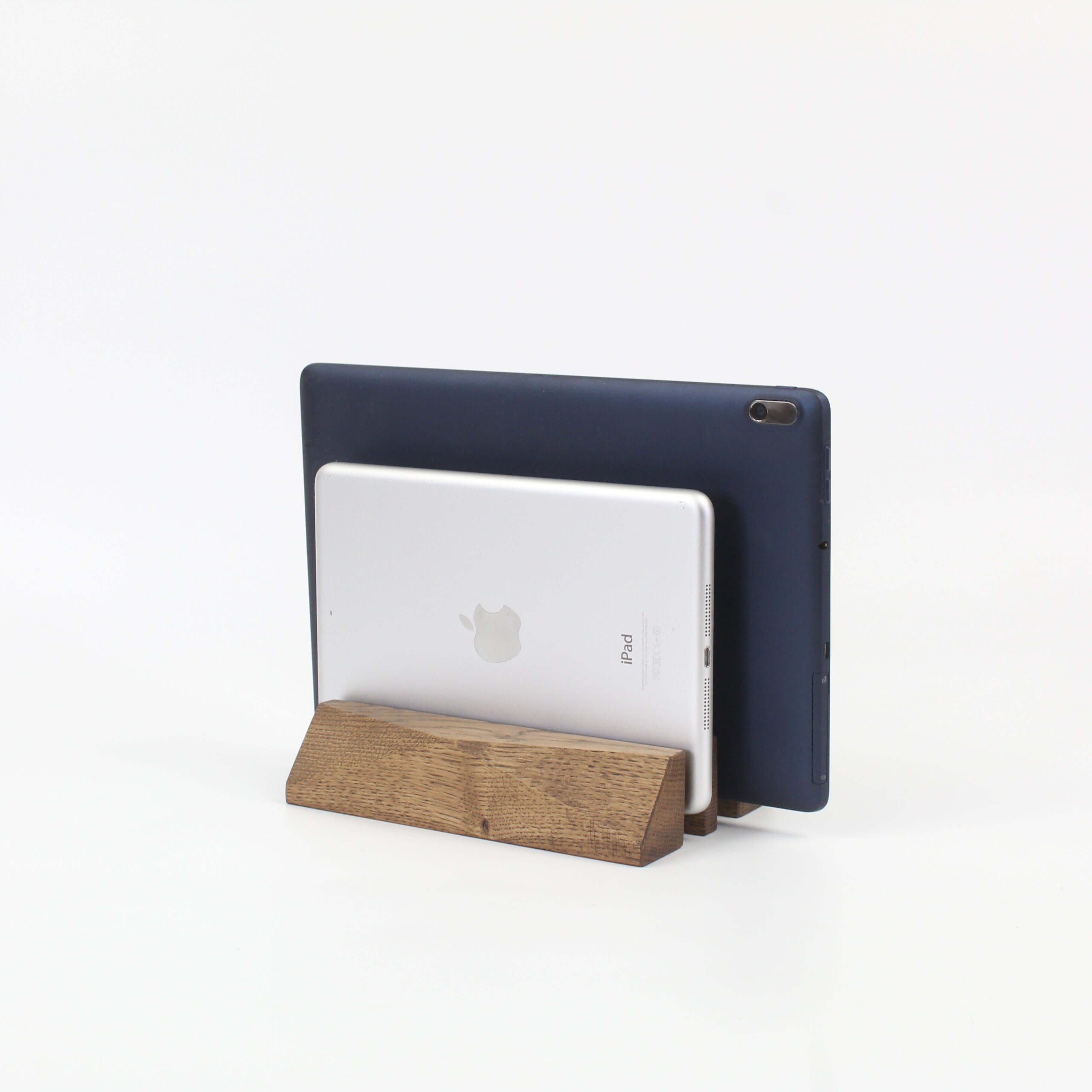 Dual laptop stand in brown oak holding a silver tablet and a dark tablet, enhancing workspace organization and elegance.