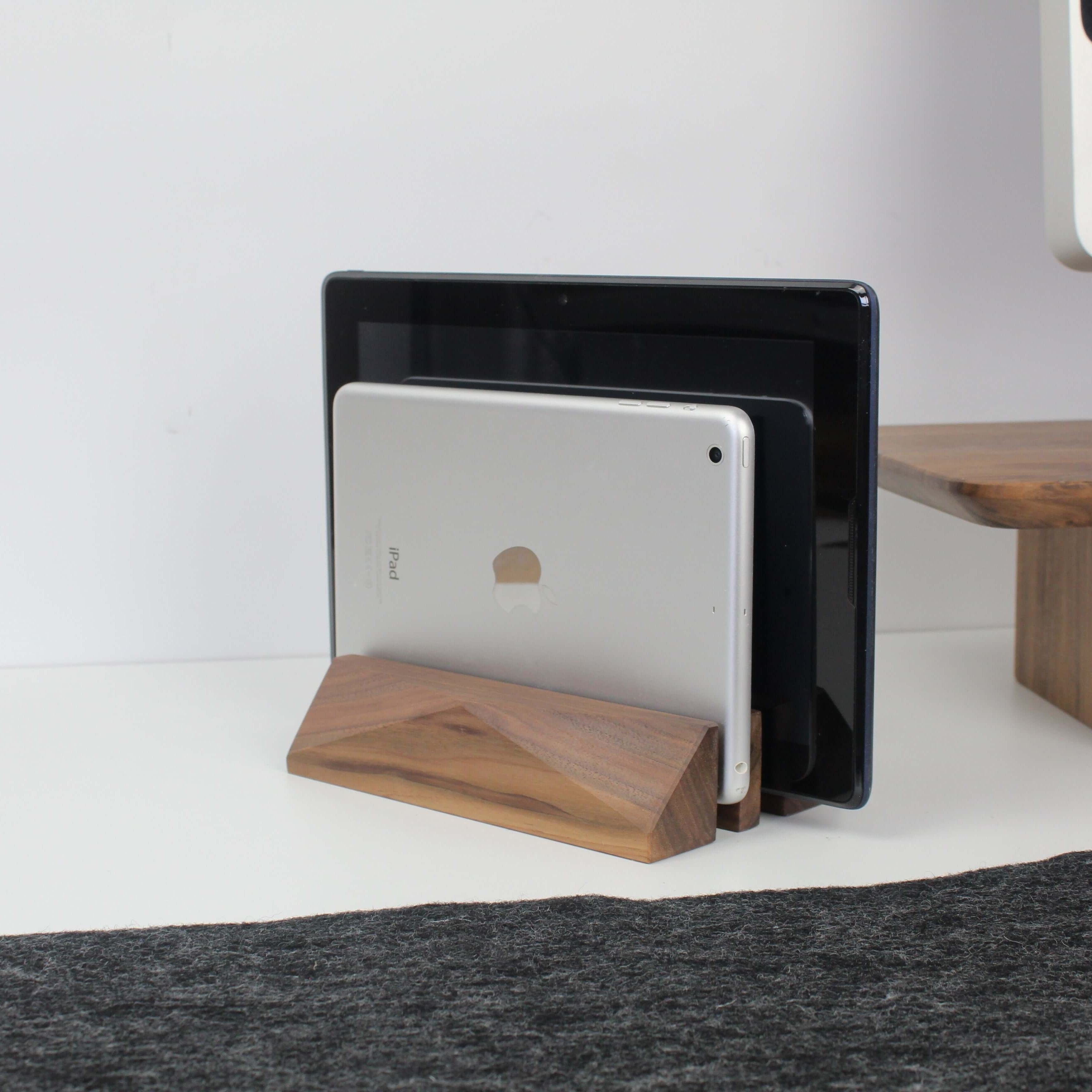 Dual laptop stand in walnut wood, neatly holding two devices on a minimalist desk for organized workspace.