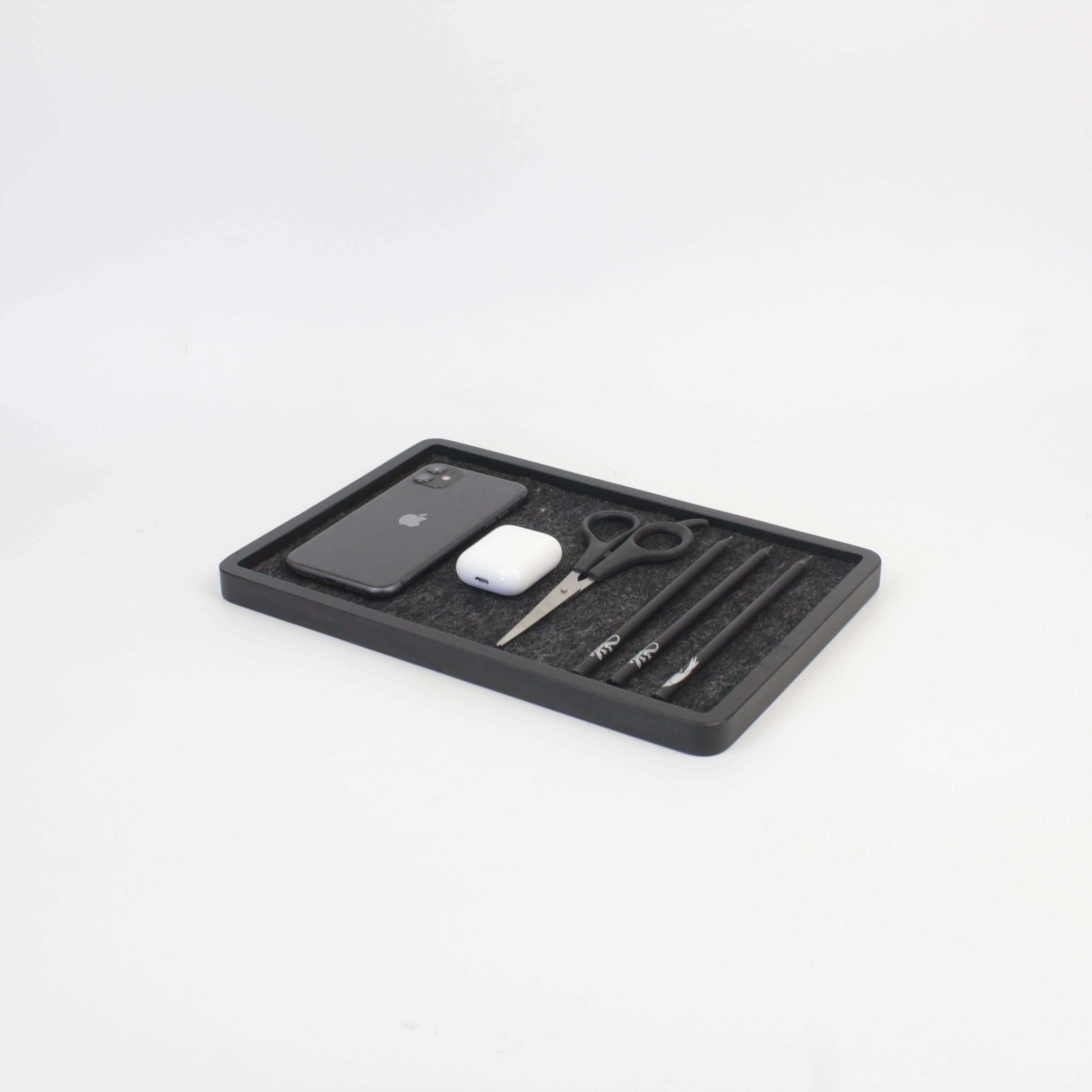 Catch All Tray in black oak holding a phone, AirPods, scissors, and pens for organized space.