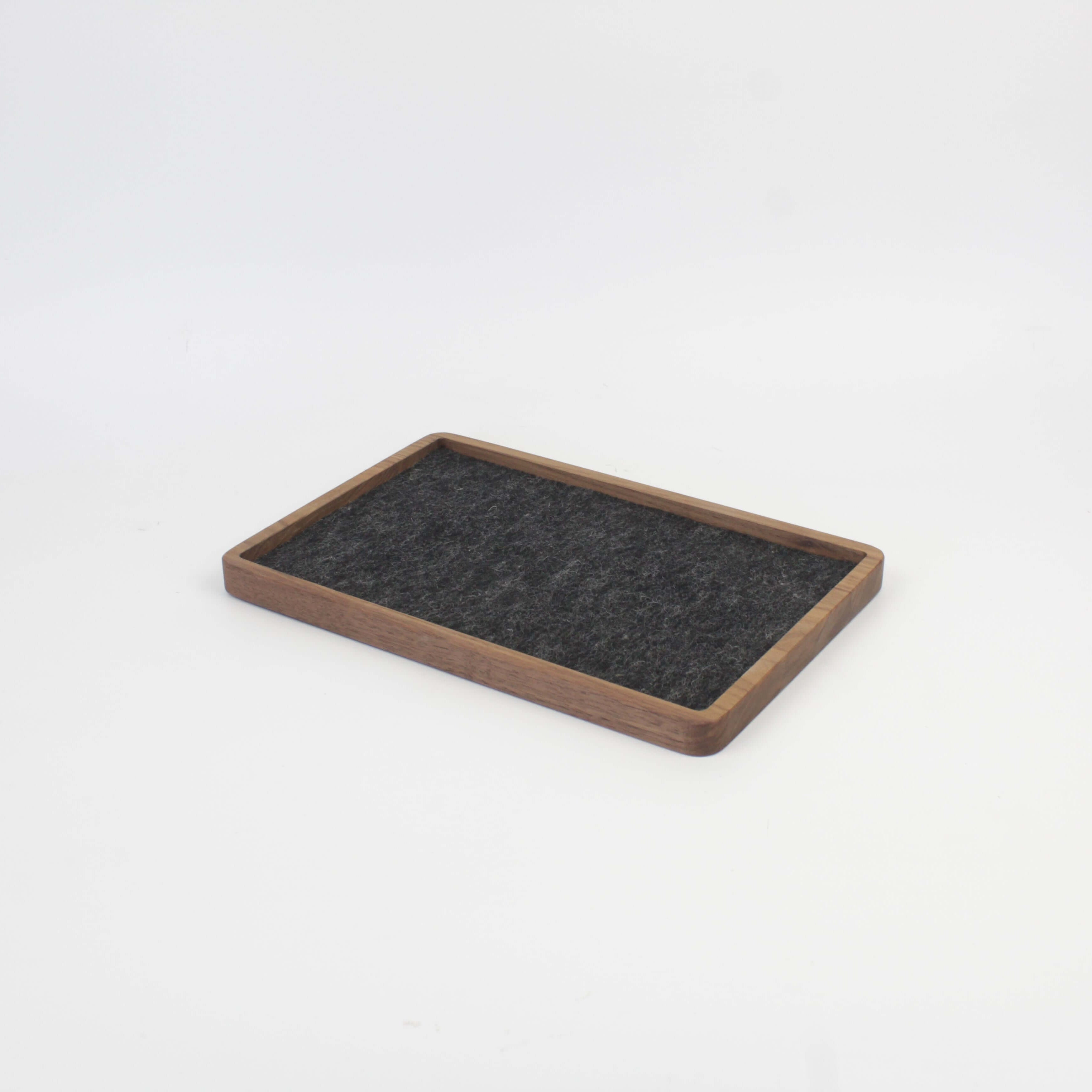 Walnut catch all tray with felt surface, ideal for organizing gadgets and accessories on desk or nightstand.