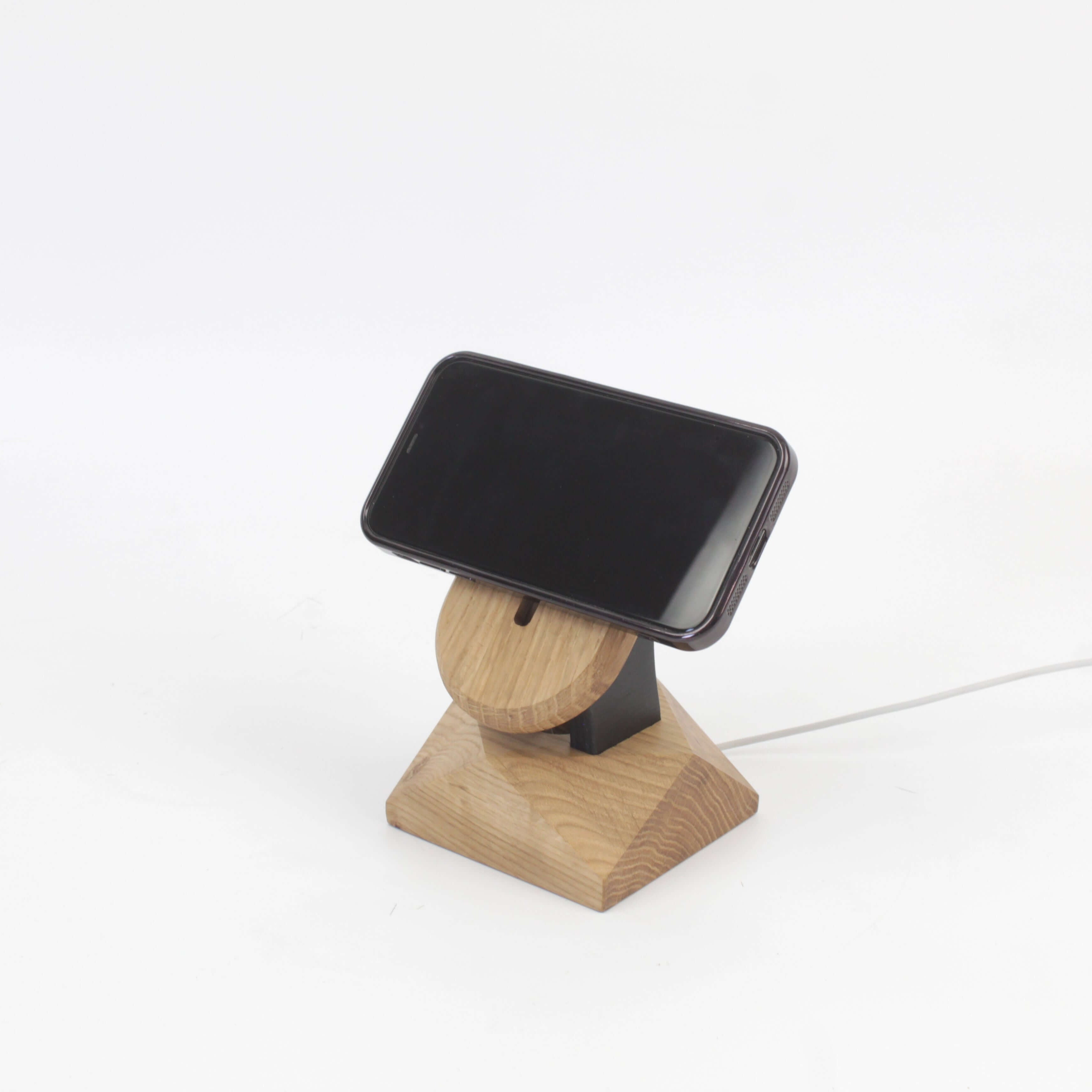 Handcrafted oak MagSafe iPhone stand serving as a minimalist wireless charger and stylish iPhone accessory.