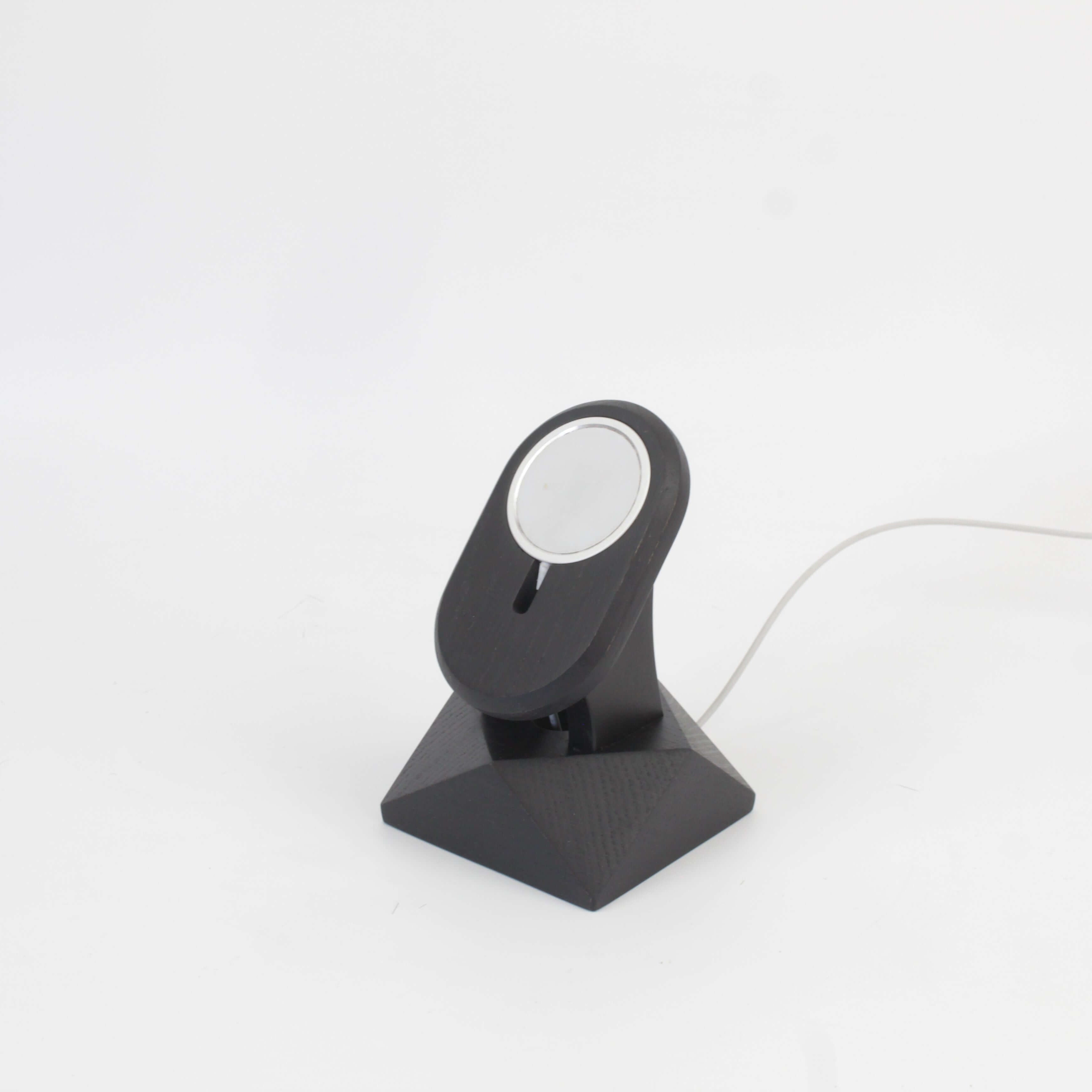 Handcrafted black oak MagSafe stand for iPhone, featuring a minimalist design and wireless charging capability.