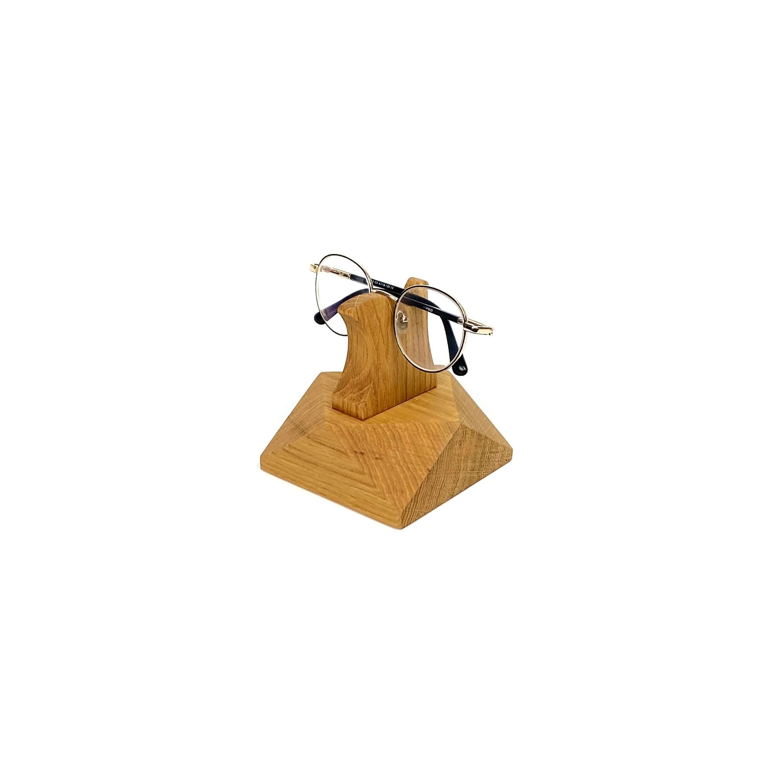 Handcrafted wooden eyeglasses stand holding stylish glasses, perfect for desk or nightstand organization.