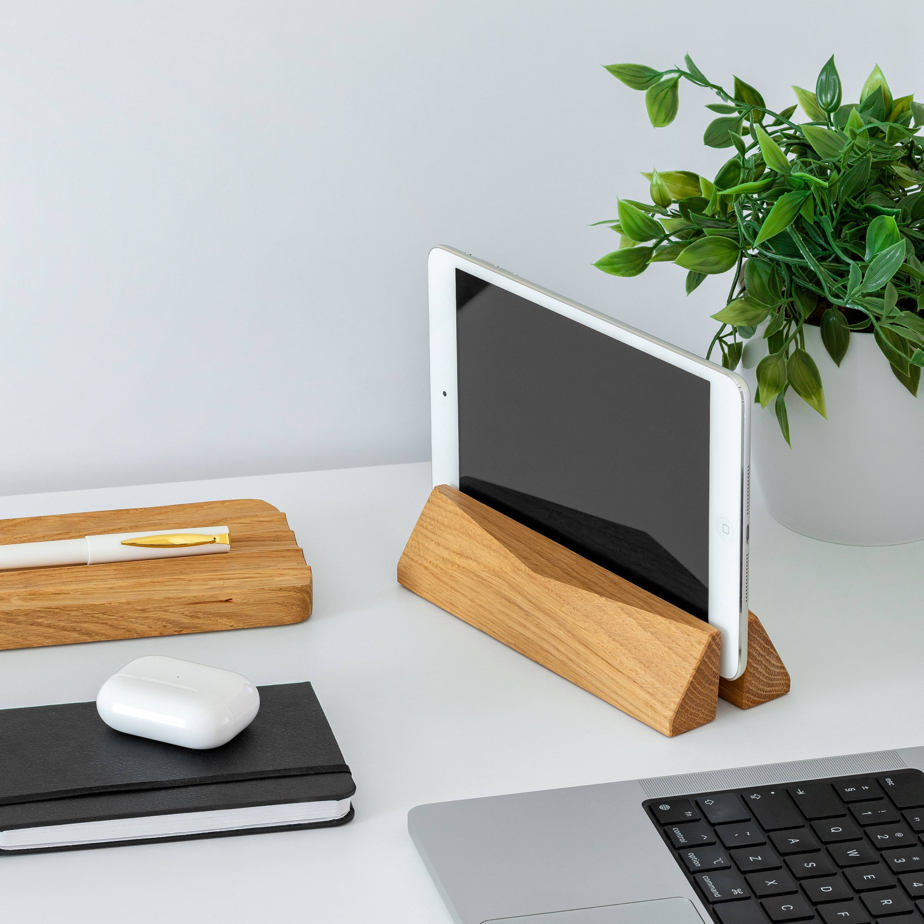 Laptop Dock - Walnut: Stylish vertical dock for laptops and tablets on a clean workspace with wooden accessories.