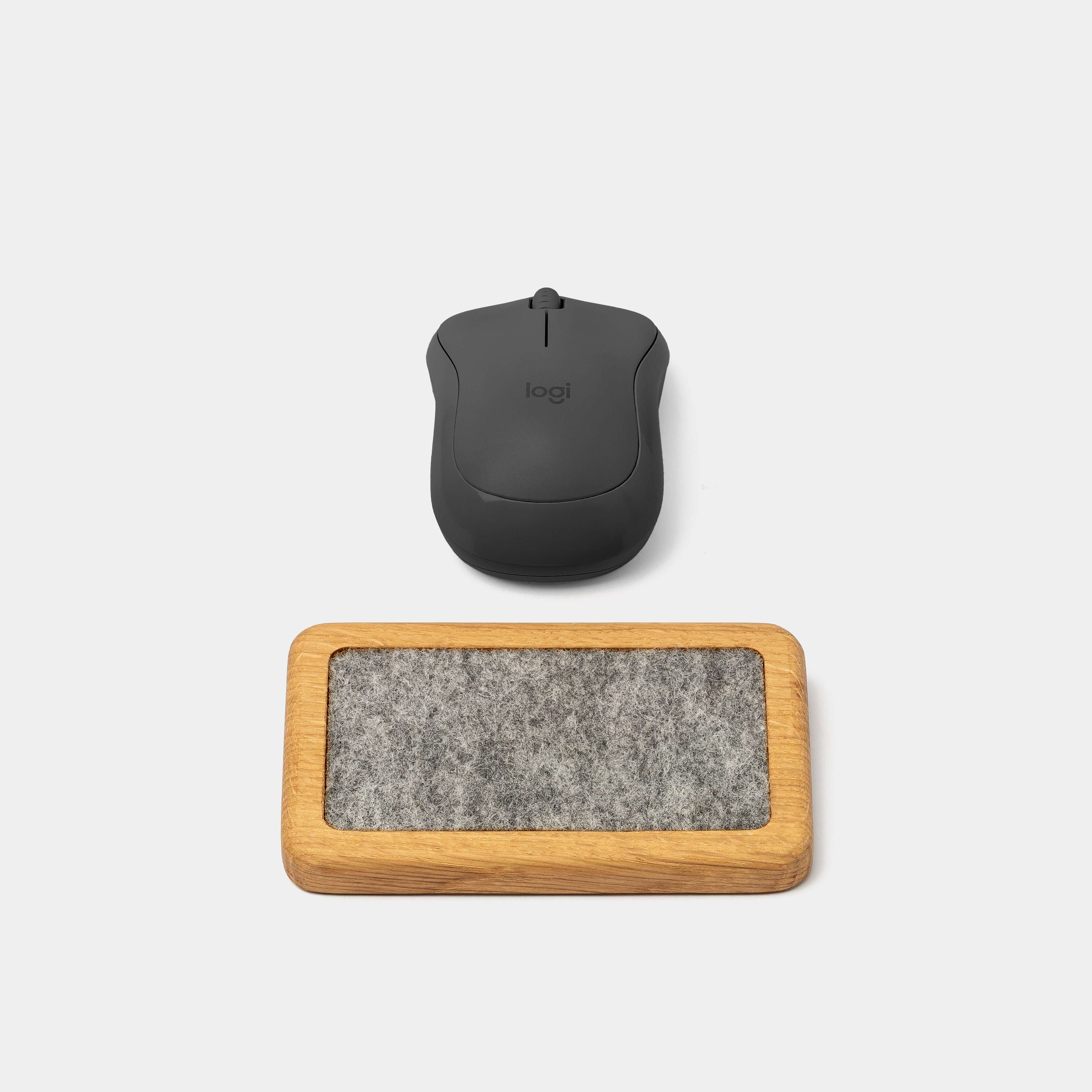 Mouse Wrist Rest - Oak with a sleek black computer mouse on a light background.