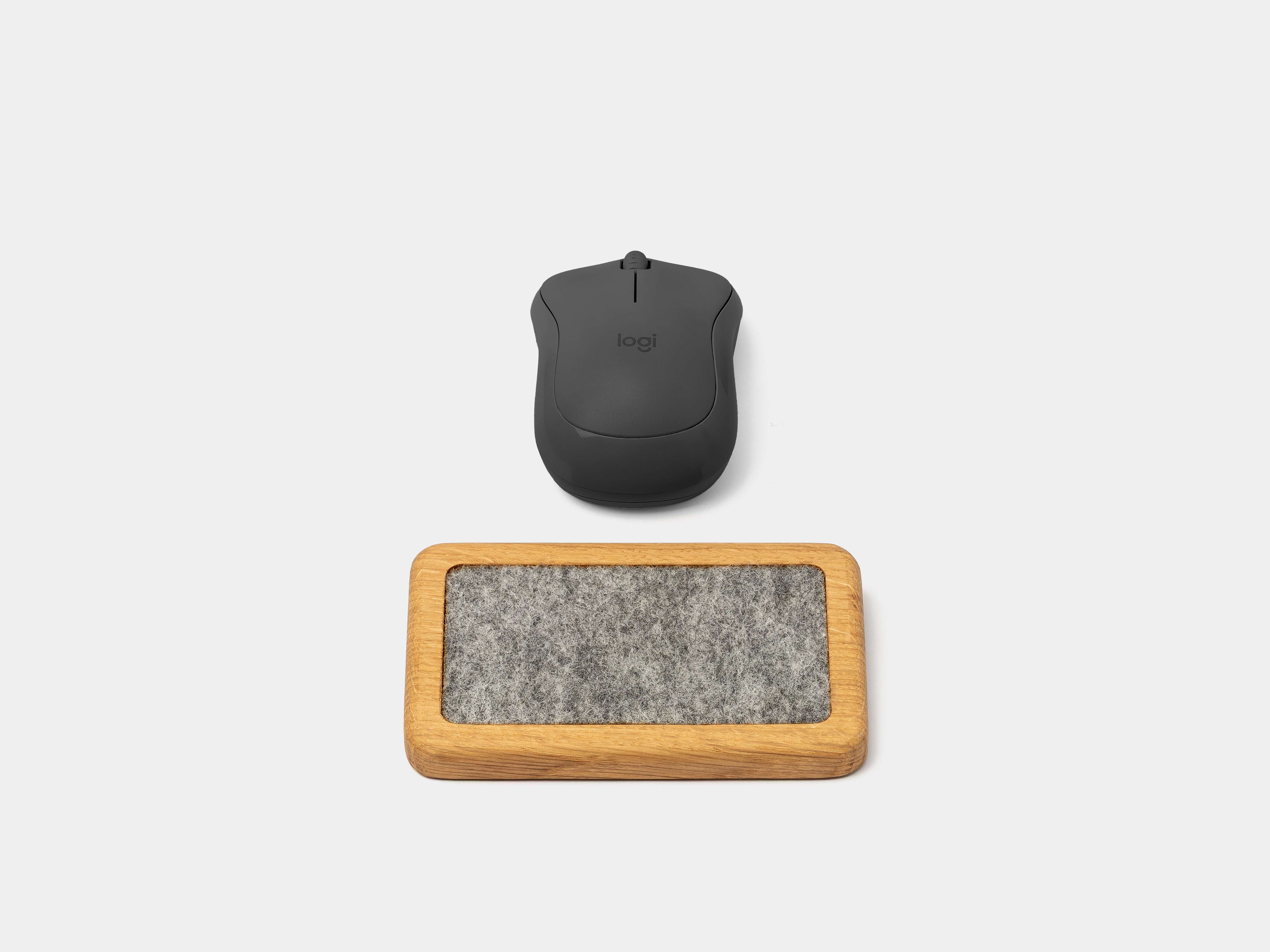 Mouse Wrist Rest - Oak with a sleek black computer mouse on a light background.