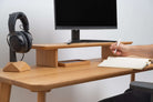 Wooden Table Top used as a workspace with a computer monitor, headphones, and notepad.