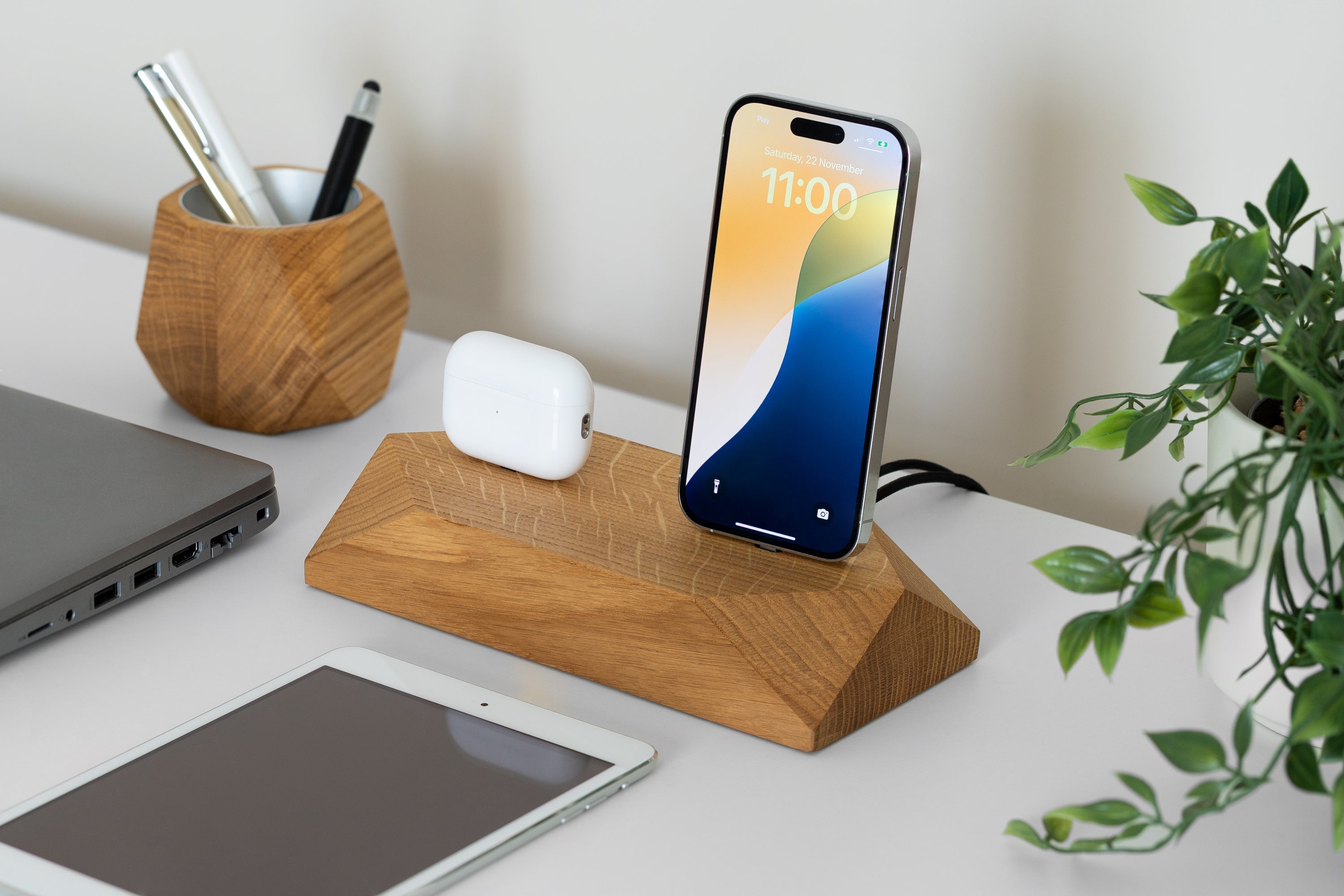 Dual Phone Dock - Black Oak charging two devices simultaneously on a clean desk with a plant.