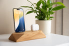 Dual Phone Dock - Brown Oak displaying a phone and headphones on a stylish desk.