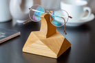 Handcrafted wooden eyeglasses stand displaying stylish glasses on a desk, perfect for organization and home decor.