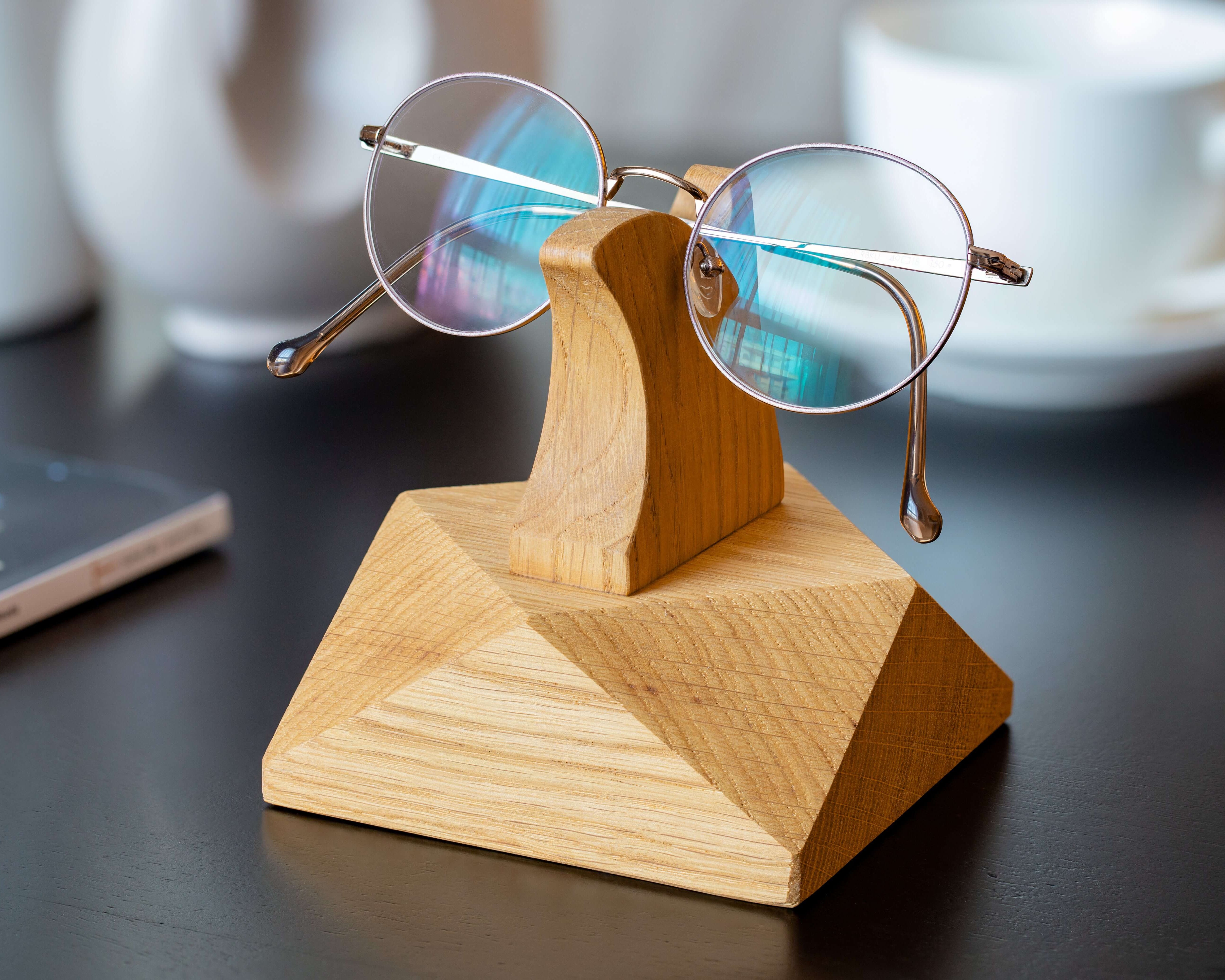 Handcrafted wooden eyeglasses stand displaying stylish glasses on a desk, perfect for organization and home decor.