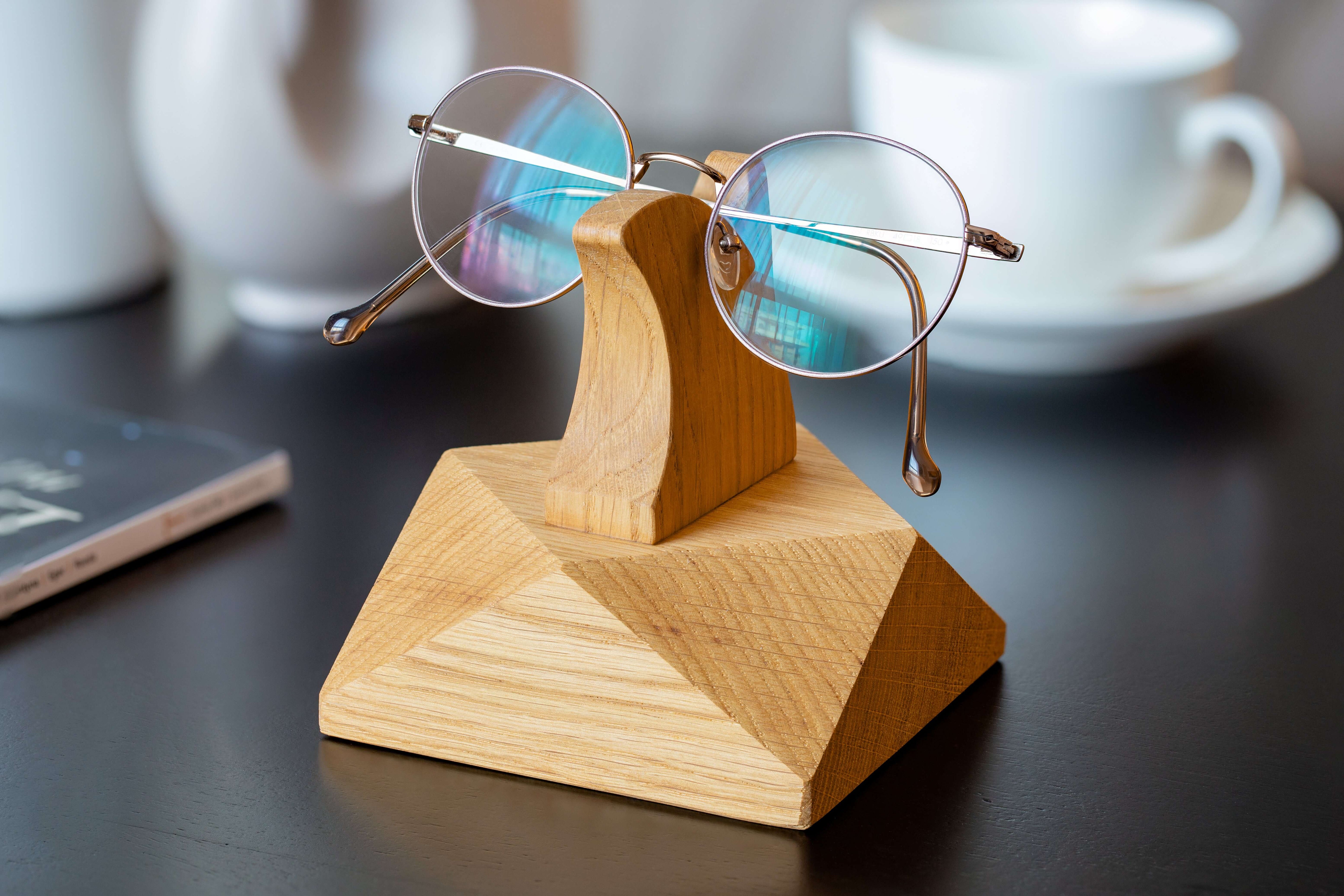 Handcrafted wooden eyeglasses stand displaying stylish glasses on a desk, perfect for organization and home decor.