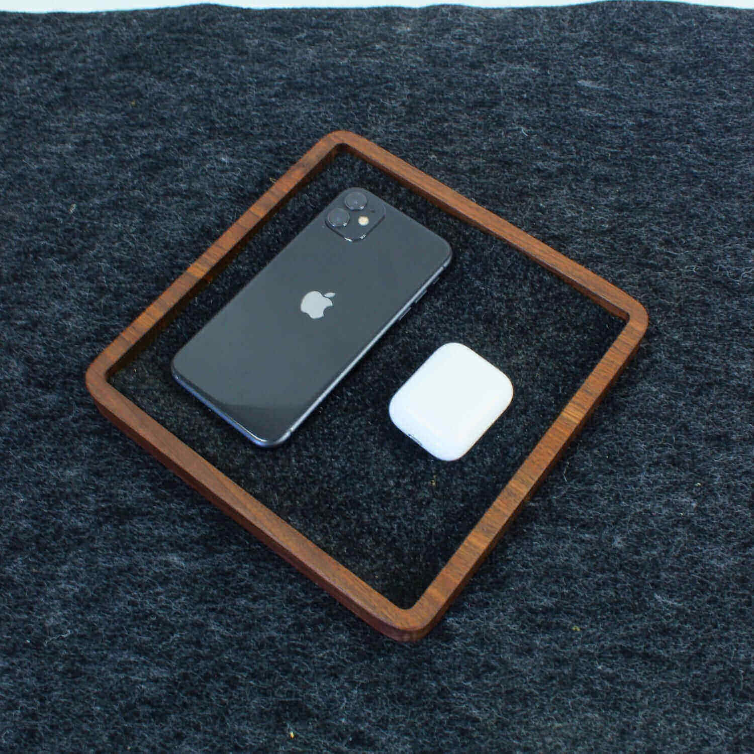 Catch All Tray in walnut holding a smartphone and earbuds on a sleek surface for organization.