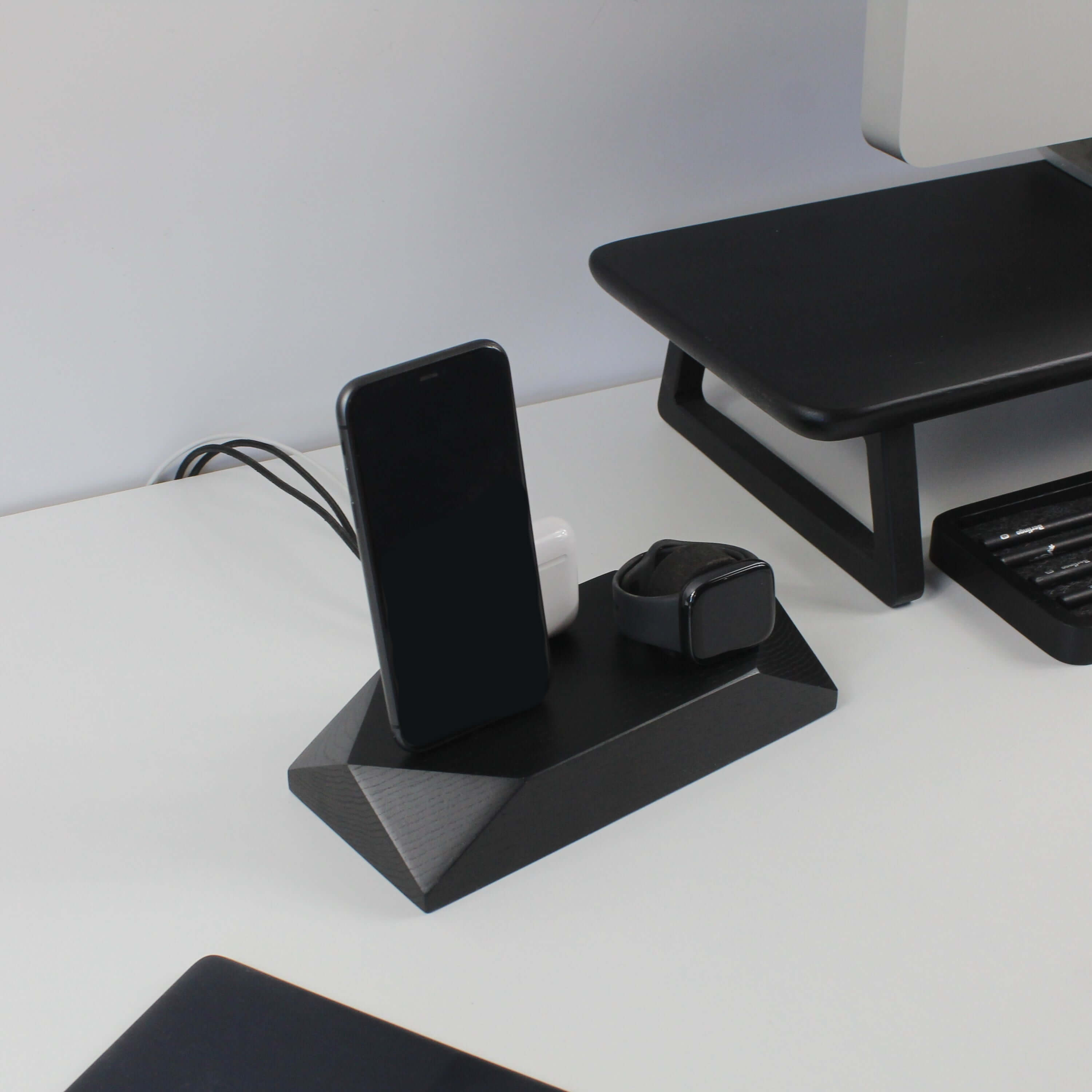 Triple Docking Station in Black Oak holding two smartphones and an Apple Watch, perfect workspace organization and sleek phone accessories.