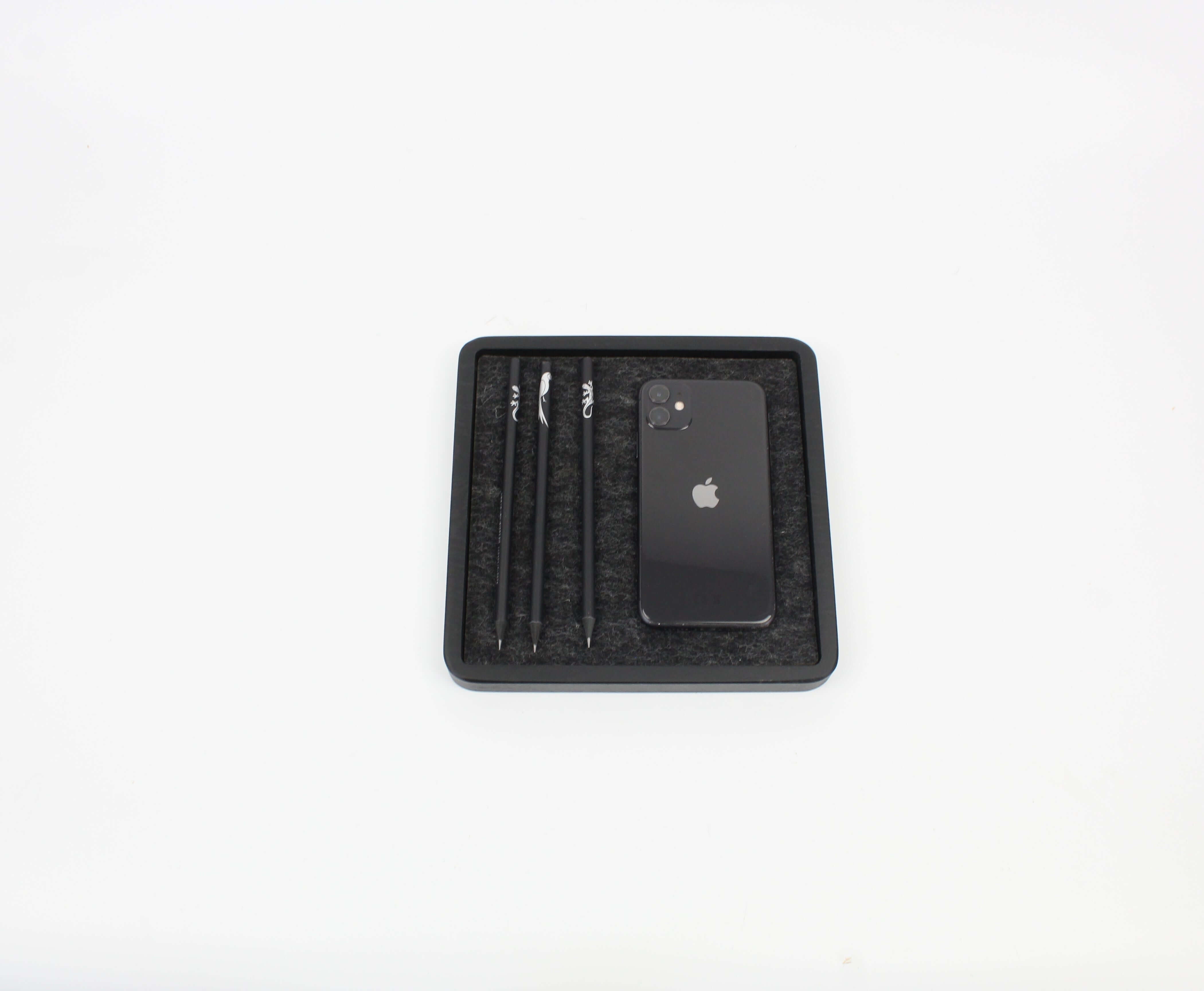 Black oak catch all tray with phone and pens organized, ideal desk accessory for a tidy workspace.