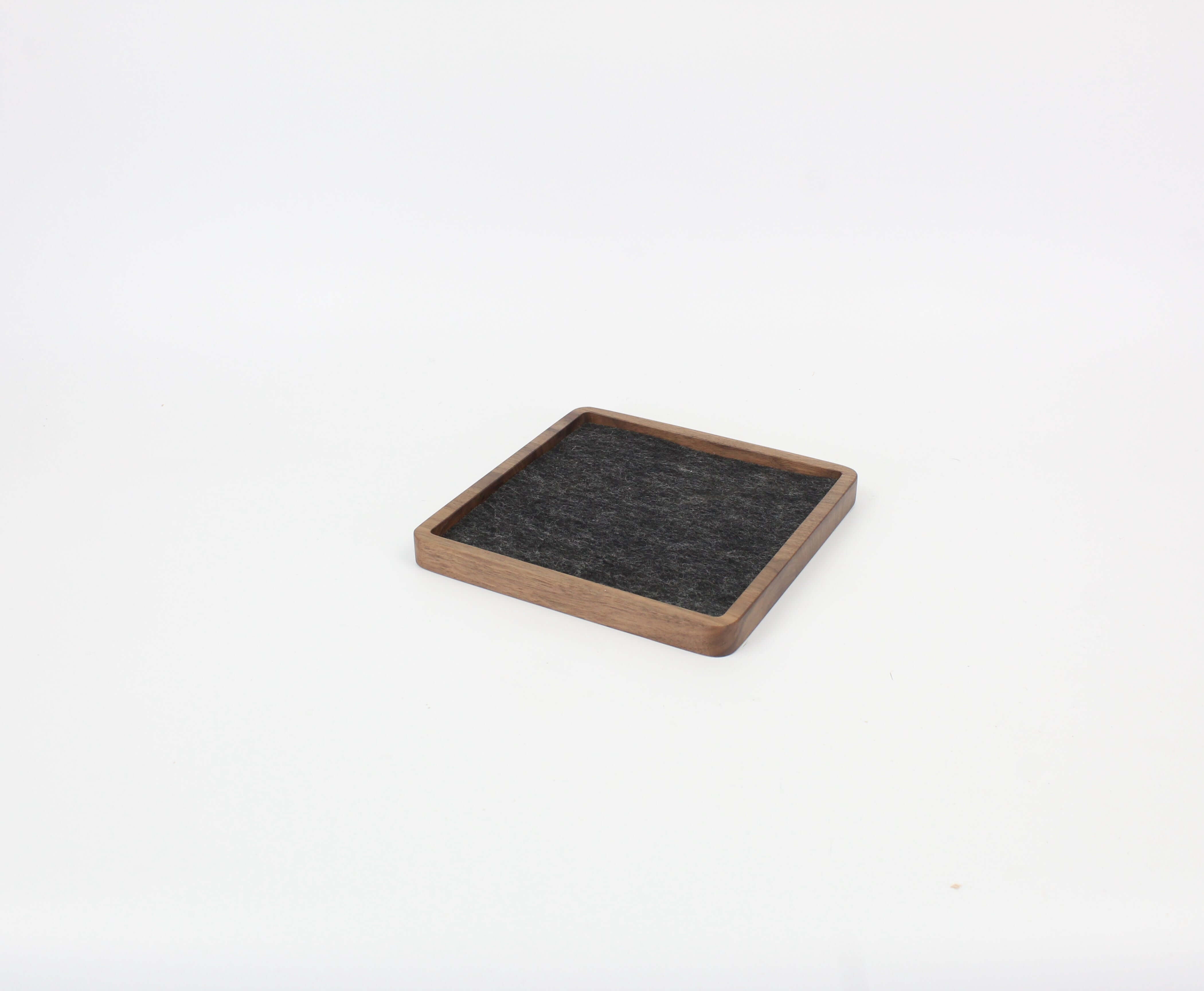 Square walnut catch all tray with felt lining, ideal for organizing desk essentials and enhancing workspace aesthetics.