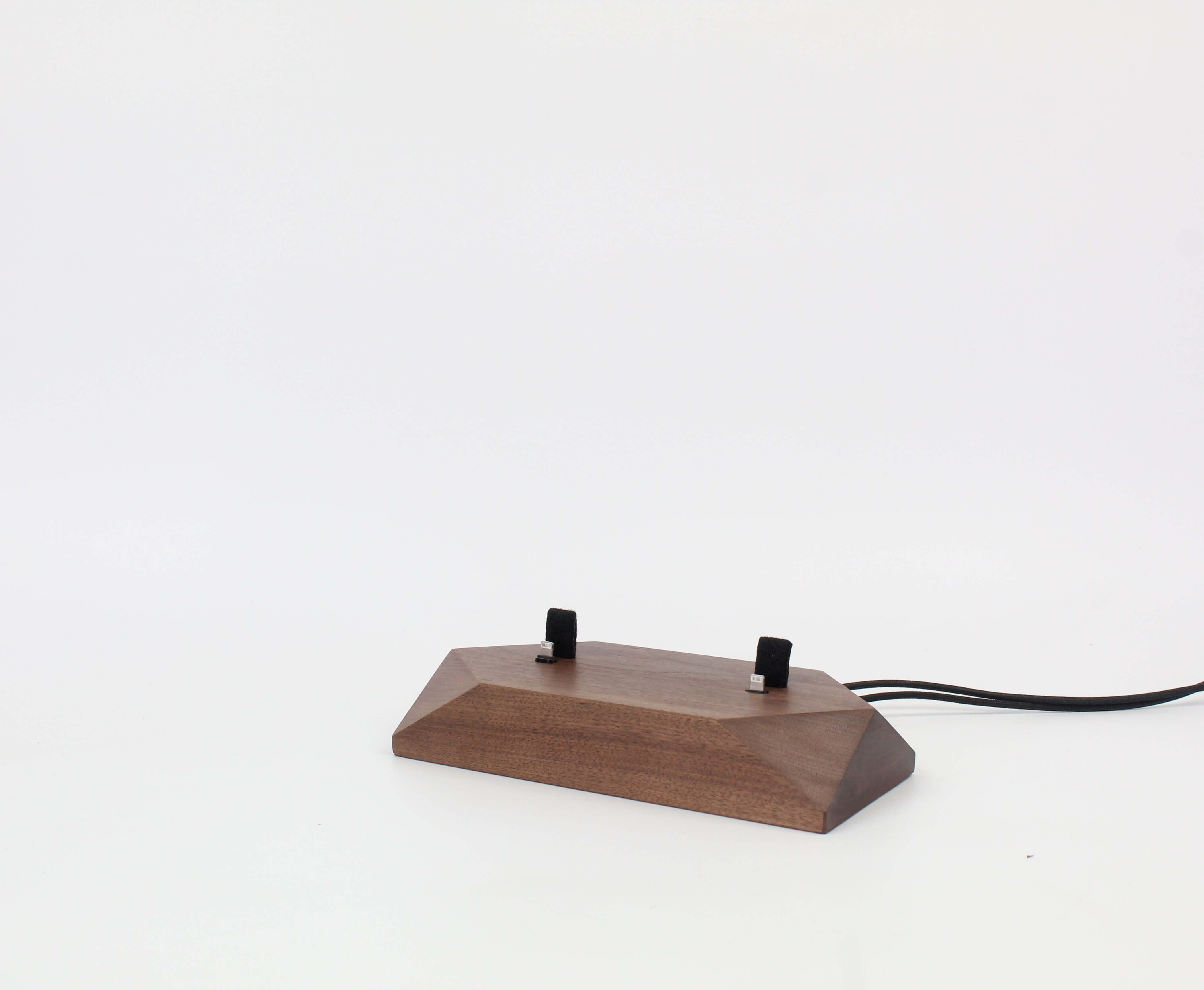 Dual phone dock in walnut wood, designed as a charging station for two devices, reducing cable clutter on your desk.