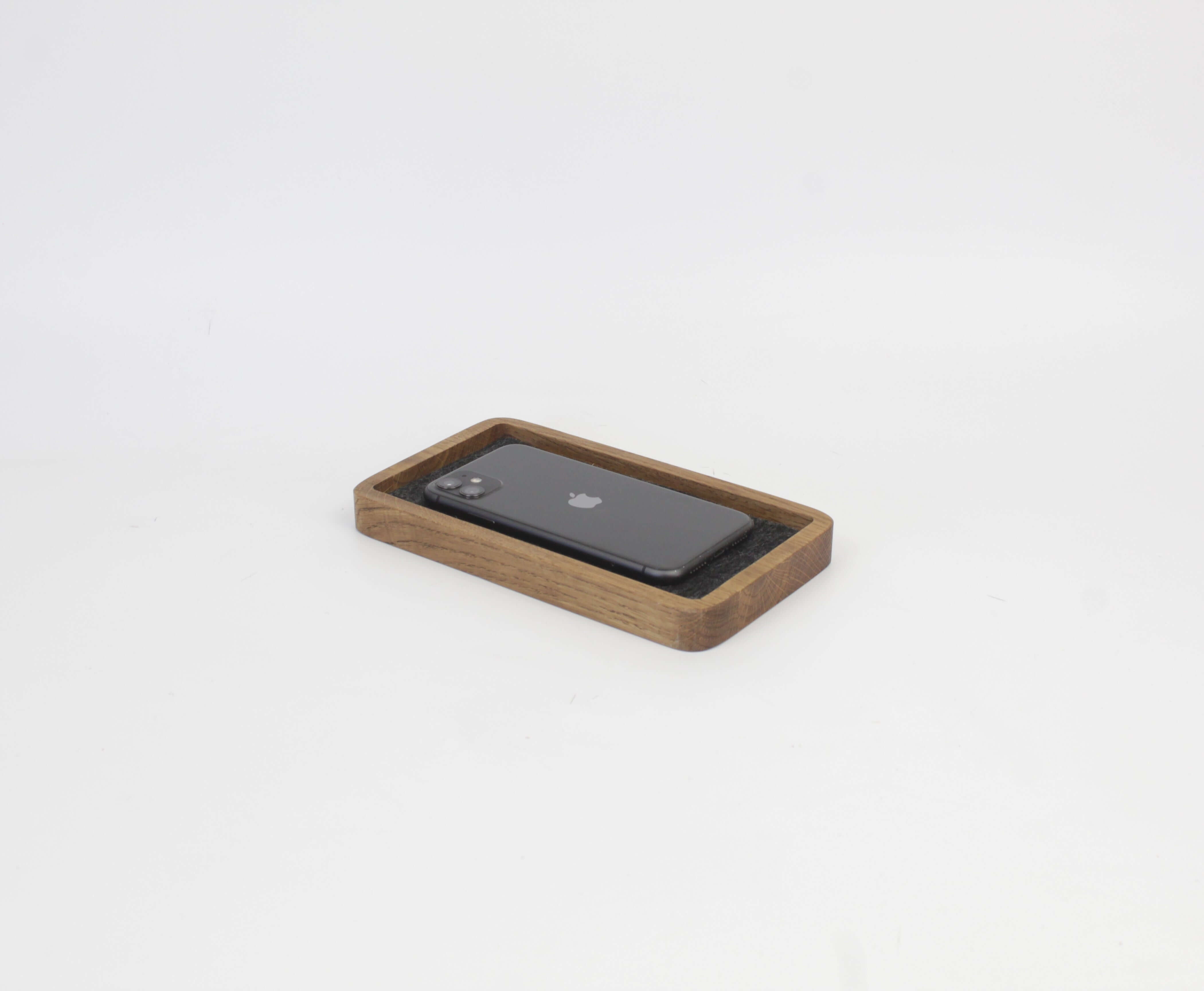 Brown oak desk tray holding a smartphone, perfect for organizing accessories and maintaining a clutter-free space.