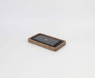 Catch all walnut tray holding a smartphone, ideal for desk organization and clutter-free spaces.