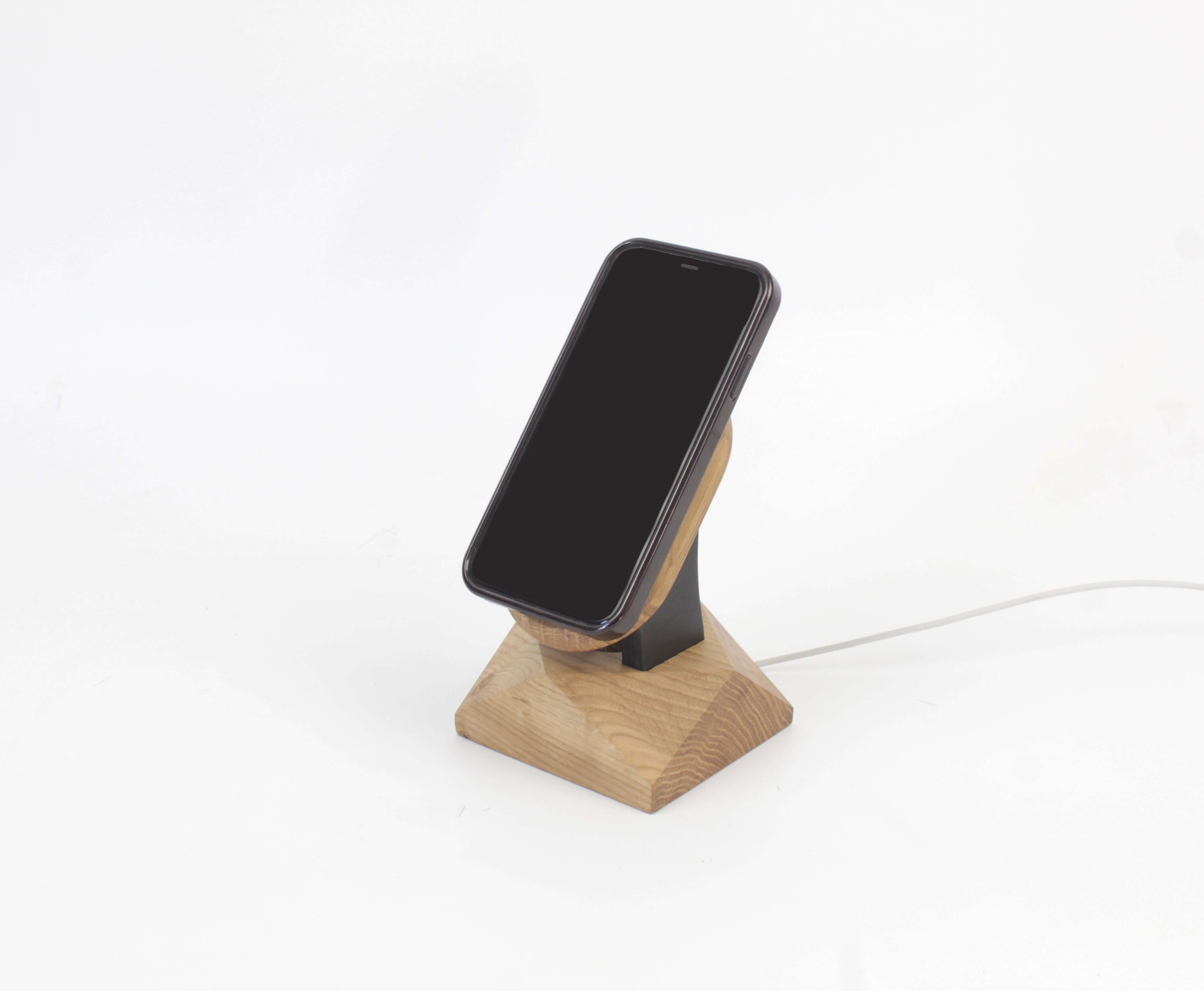 Handcrafted oak MagSafe iPhone stand, a stylish and minimalist wireless charger for your iPhone accessories.