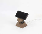 MagSafe iPhone stand in brown oak with a phone, showcasing a minimalist design for iPhone wireless charging.