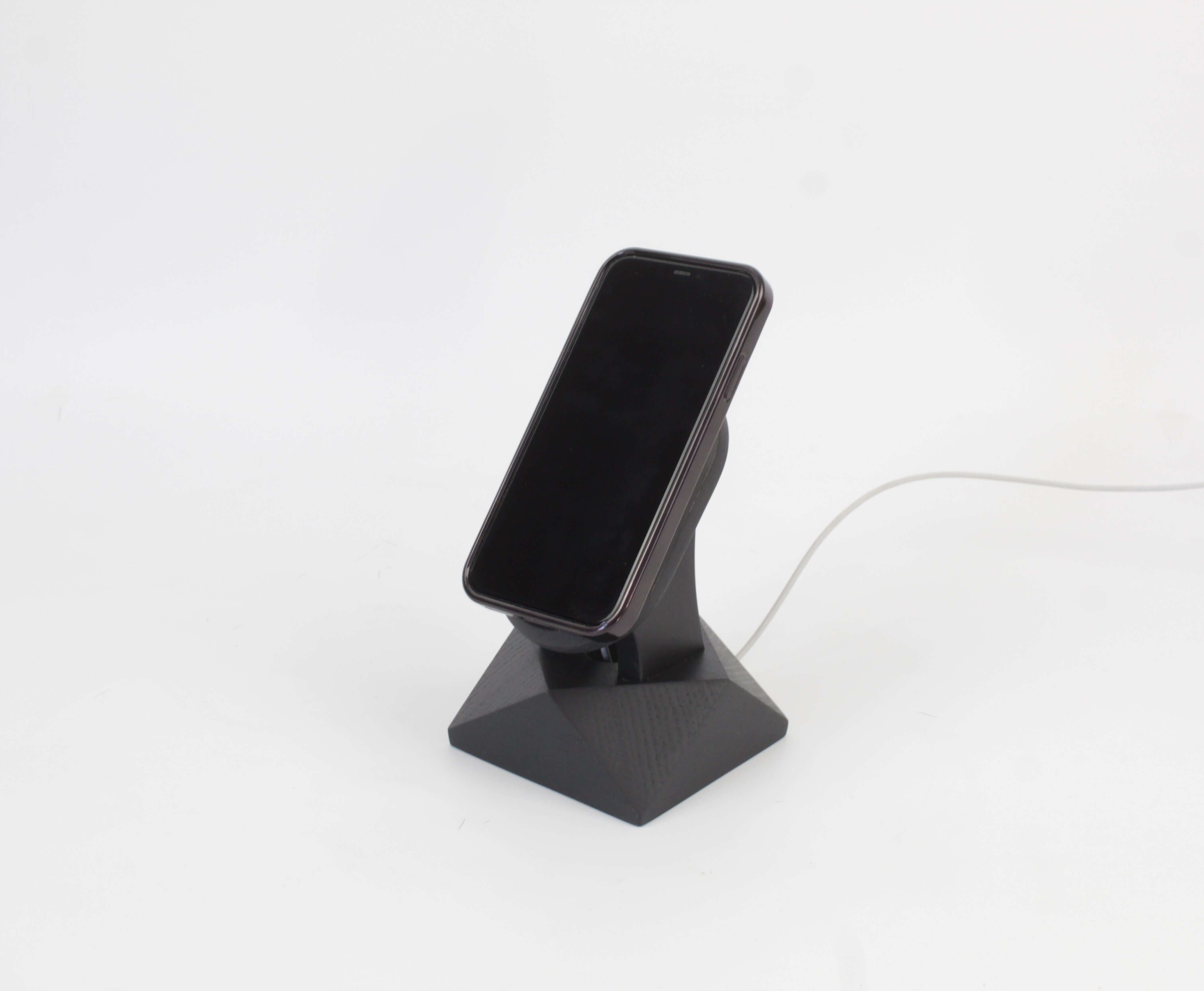 Handcrafted black oak MagSafe iPhone stand showcasing a sleek design for wireless charging and modern aesthetics.