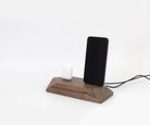 Dual charging station in walnut finish for phone and headphones, elegant desk organization solution.