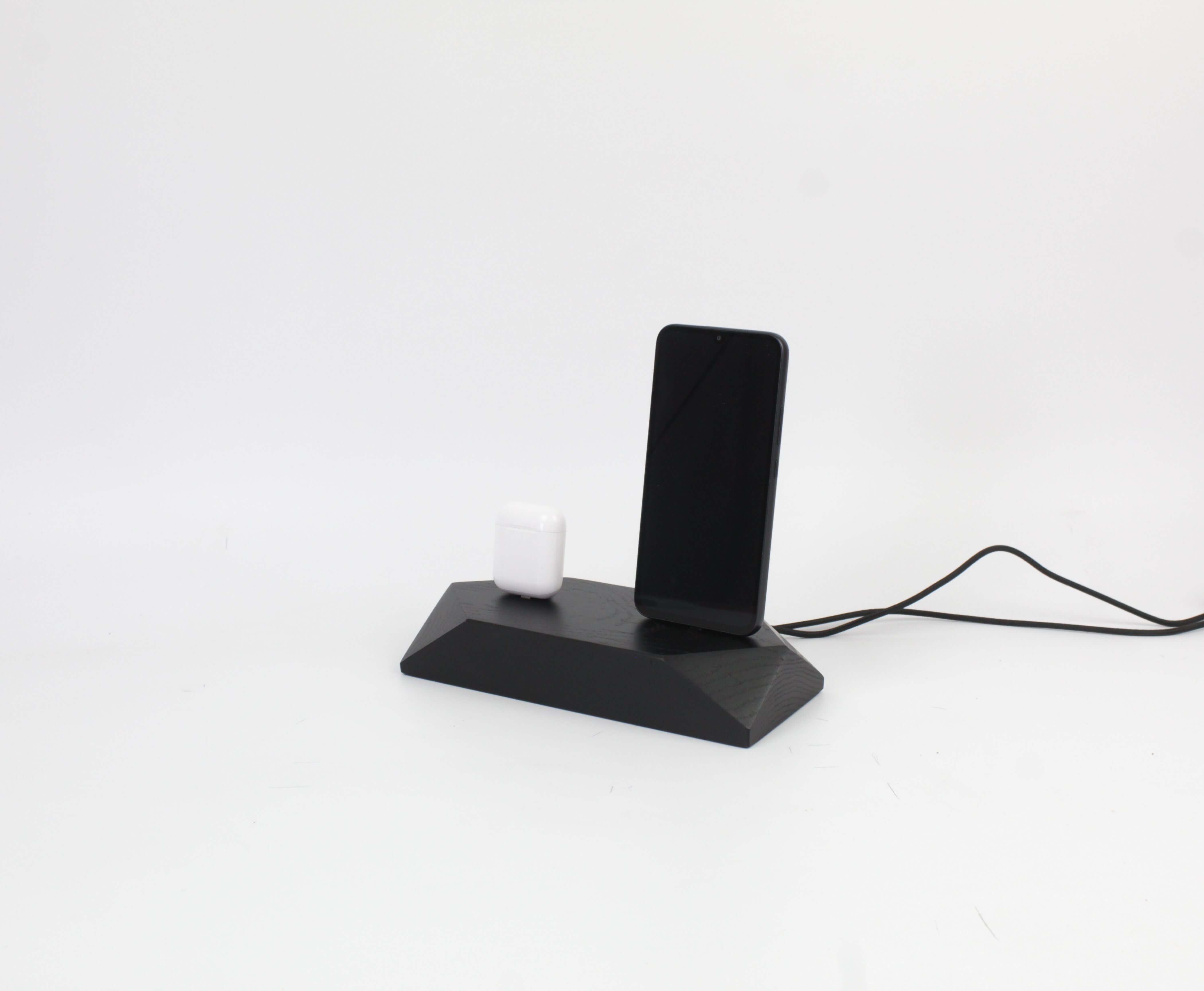 Dual Phone Dock in stained black oak charging an iPhone and AirPods, reducing desk clutter with a sleek design.