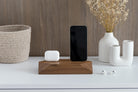 Dual Phone Dock - Walnut on a desk with phone and AirPods, offering convenient device charging.