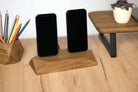 Dual phone dock charging station in brown oak, holding two smartphones on a stylish wooden desk.