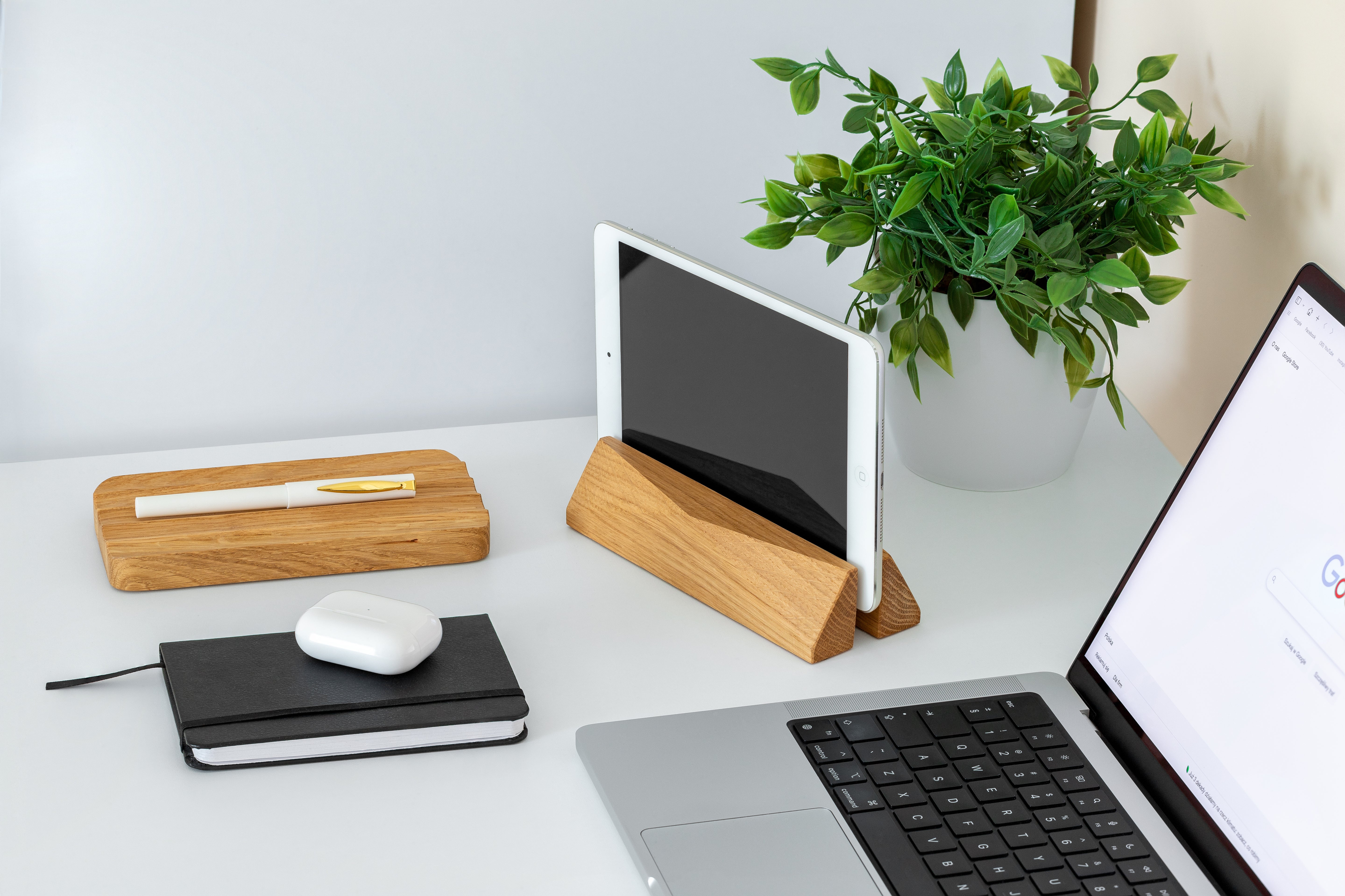 Laptop Dock - Walnut: Stylish vertical dock for laptops and tablets on a clean workspace with wooden accessories.