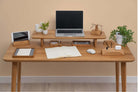 Wooden Table Top featuring a modern desk setup with laptop, plants, and stationery in a warm environment.